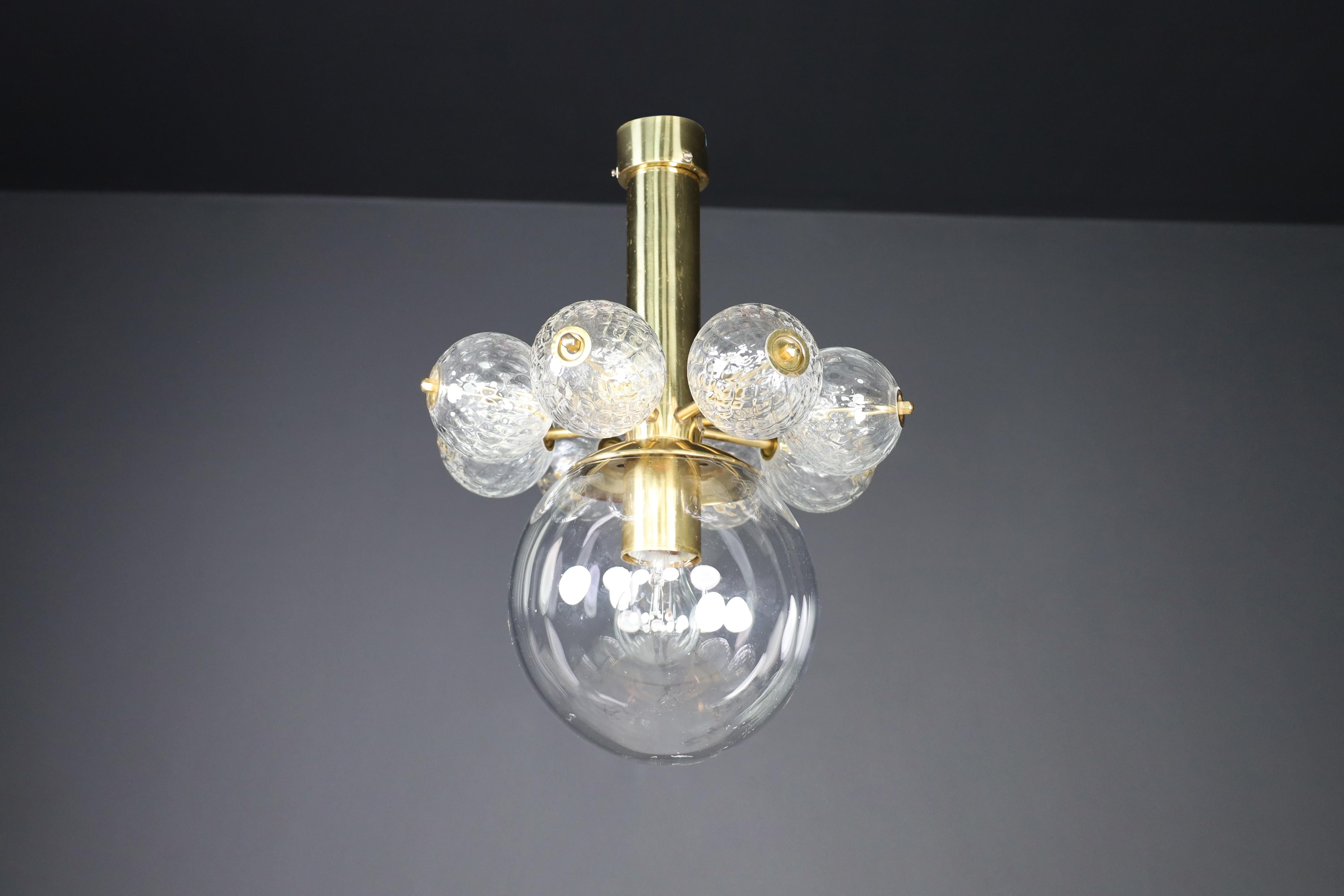 Large set chandelier with brass fixture and hand-blowed  glass globes, Cz 1960

A mid-century chandeliers with a brass fixture and hand-blown glass globes was designed and produced in Czechia during the 1960s. It features a sizeable hand-blown glass