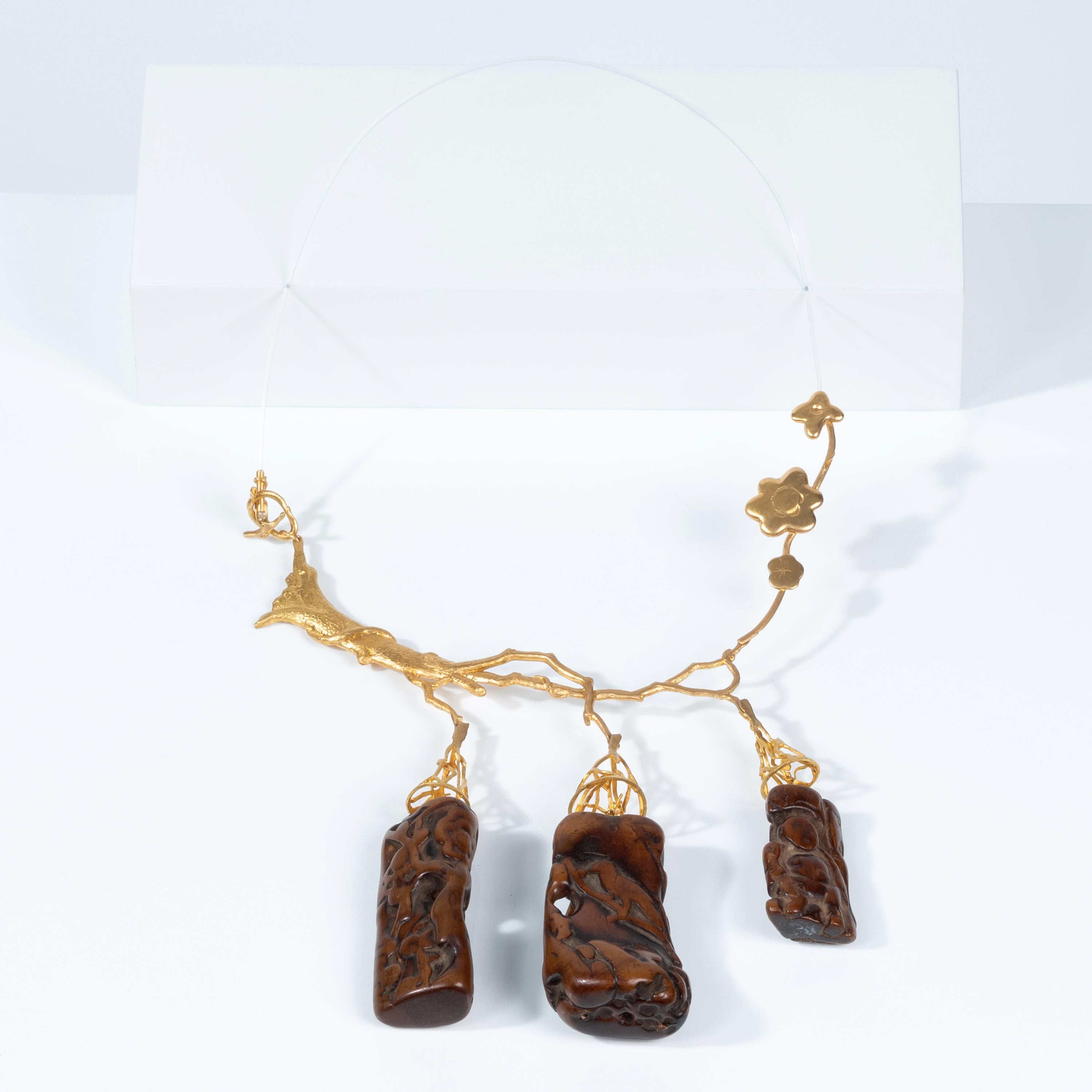 Artist and architect Daniel Azaro was asked by Mimi Lipton to craft this one-of-a-kind necklace. From a delicate 22 karat gold ribbon, hang three pendants of beautifully carved wood from China. 

With diverses subjects, symbolisms, styles and