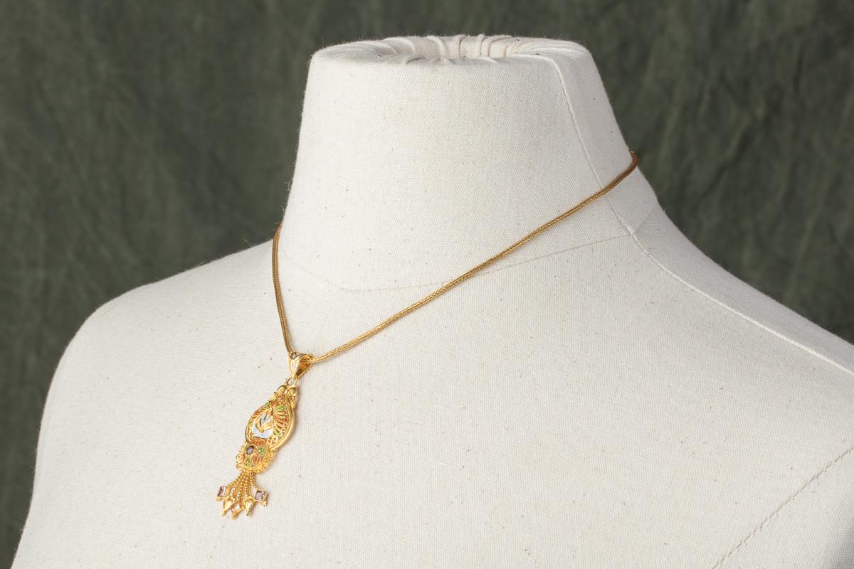 22K gold pendant with fine granulation work with a combination of clear and champagne diamonds on a hand-rolled 22K gold chain.  The footing on one side of the chain unscrews to allow the pendant to interchange.  Subtle enamel work on the pendant