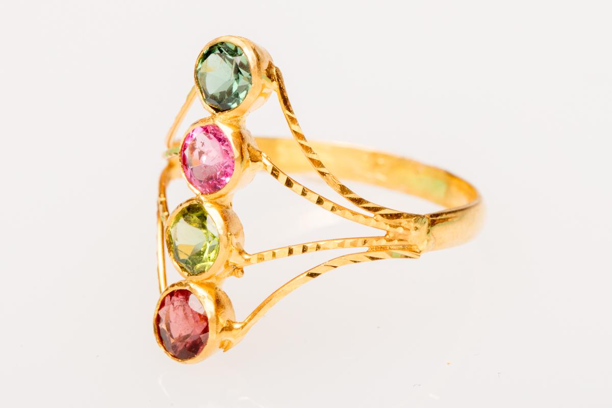 Unusually set, faceted, round tourmalines --pink, green, aqua and amber colors, in 22K gold with hand-tooled workmanship along the gold fronts.  Great quality and clarity in the tourmalines.  Ring size is 7.  Carat weight of tourmalines is 1.25.