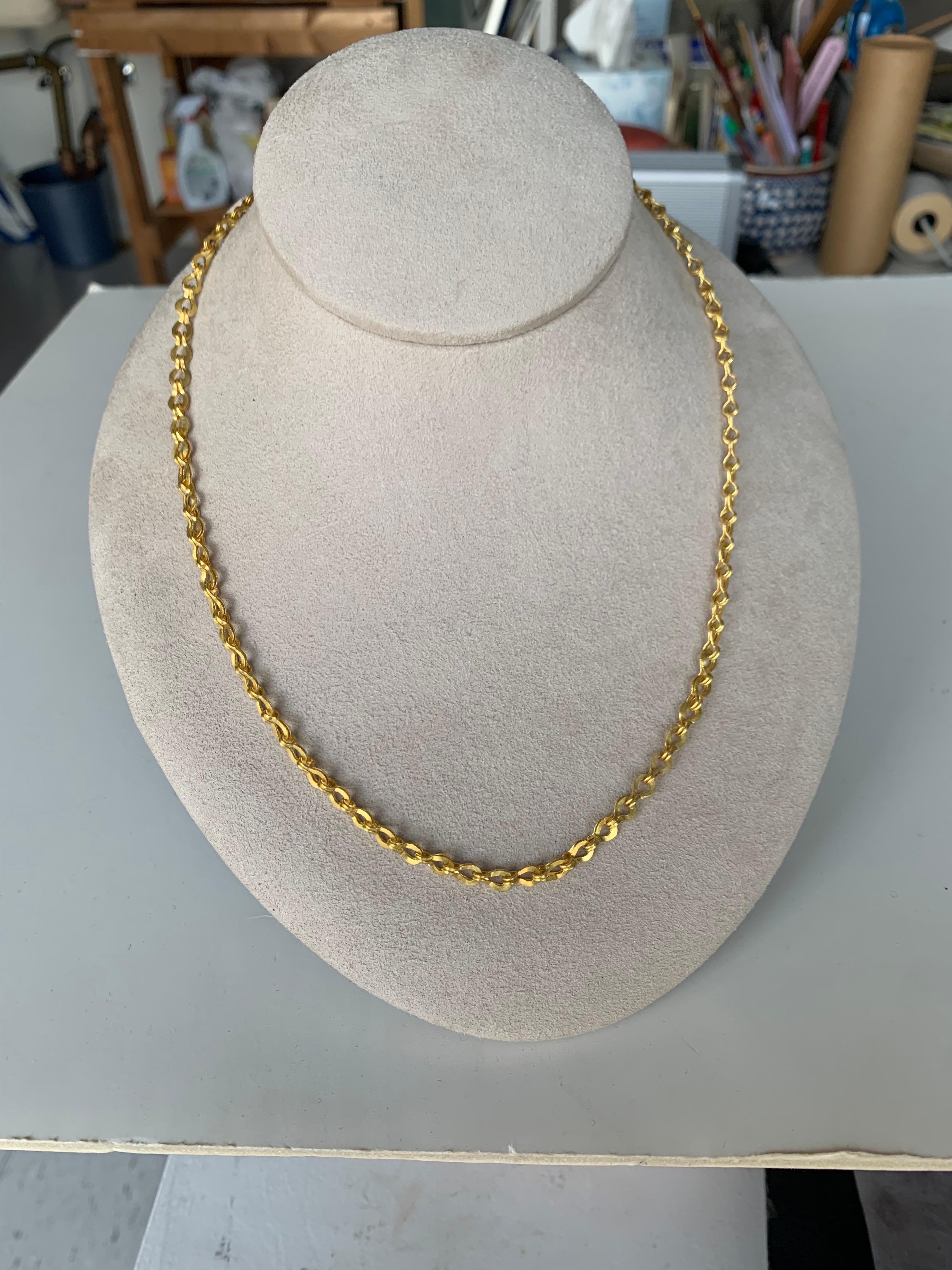 Inspired by Greek/Roman jewelry this planished Sailor's knot chain is 20 inches long with Ruby cabochon clasp and granulation.
The ruby weighs .50 carat
This lovely chain is entirely hand crafted, from  alloying the gold, pulling the wire, fusing