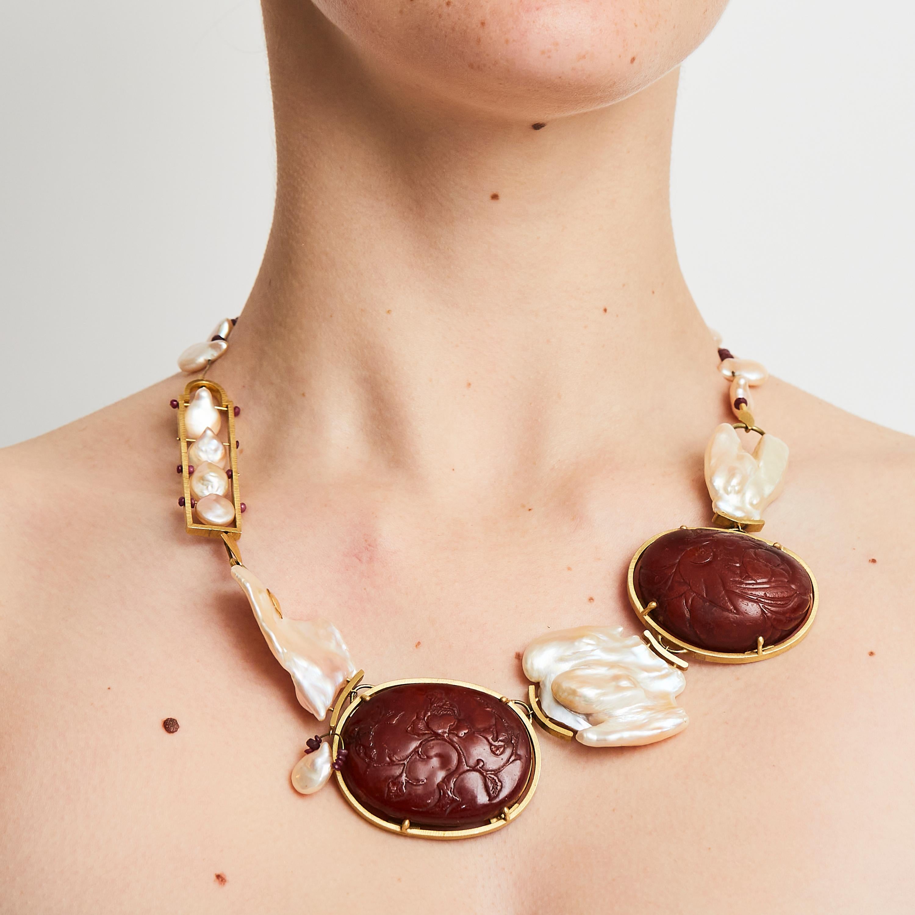 Artist and architect Daniel Azaro was asked by Mimi Lipton to craft this one-of-a-kind necklace. Timeless and bold, the jewel is adorned with rubies, Baroque pearls and Baltic amber pieces set in 22 karat gold. The amber was carved in China in the