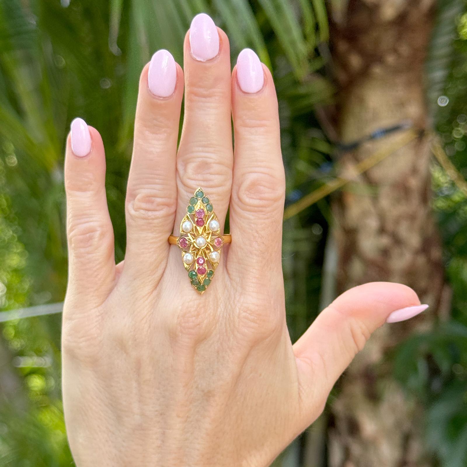 This vintage navette-style ring crafted in rich 22 karat gold features a striking combination of lustrous pearls, vibrant emeralds, and deep red rubies arranged in an elegant elongated design measuring approximately 15 x 35mm. The adjustable band