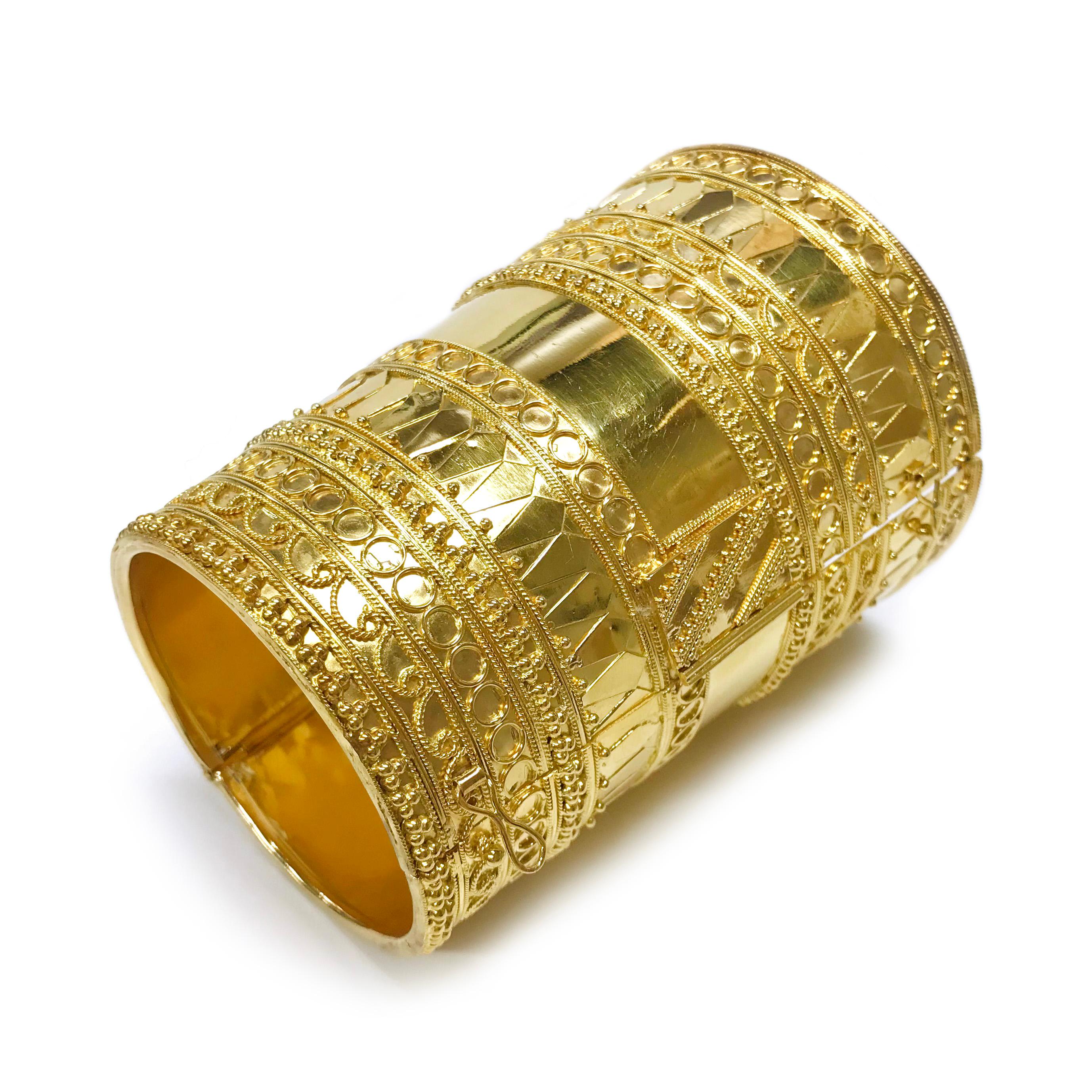 22 Karat Wide Indian hinged Bracelet. This beautiful traditional Indian hinged bracelet features meticulous milgrain detail, multiple shape designs, and gold beads. The handmade quality of this piece is exceptional. The bracelet tapers starting at