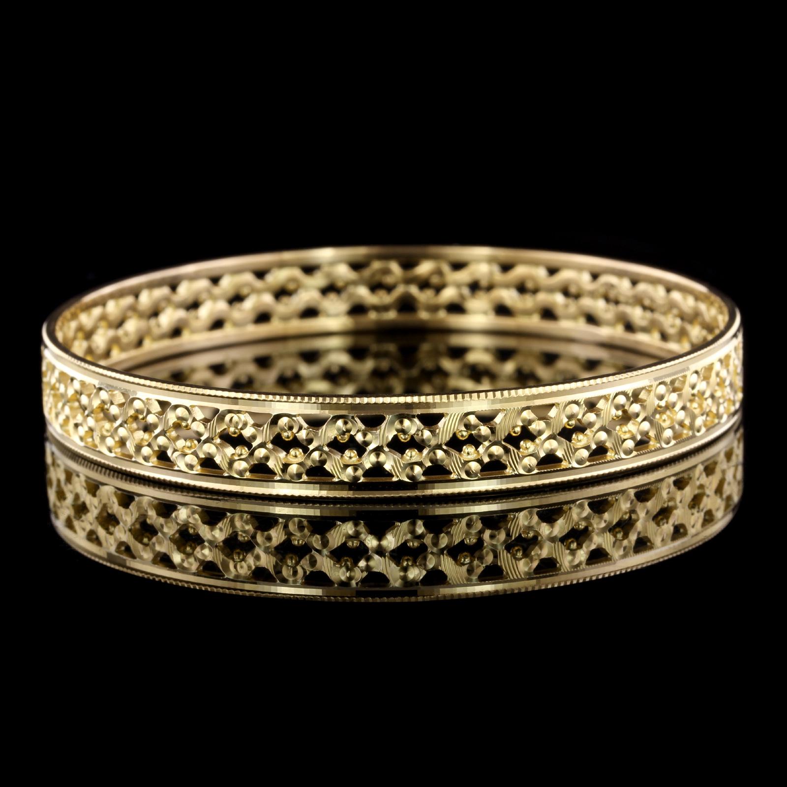 22K Yellow Gold Bangle. The bracelet measures 9.25mm. wide, interior
circumference 7 3/4