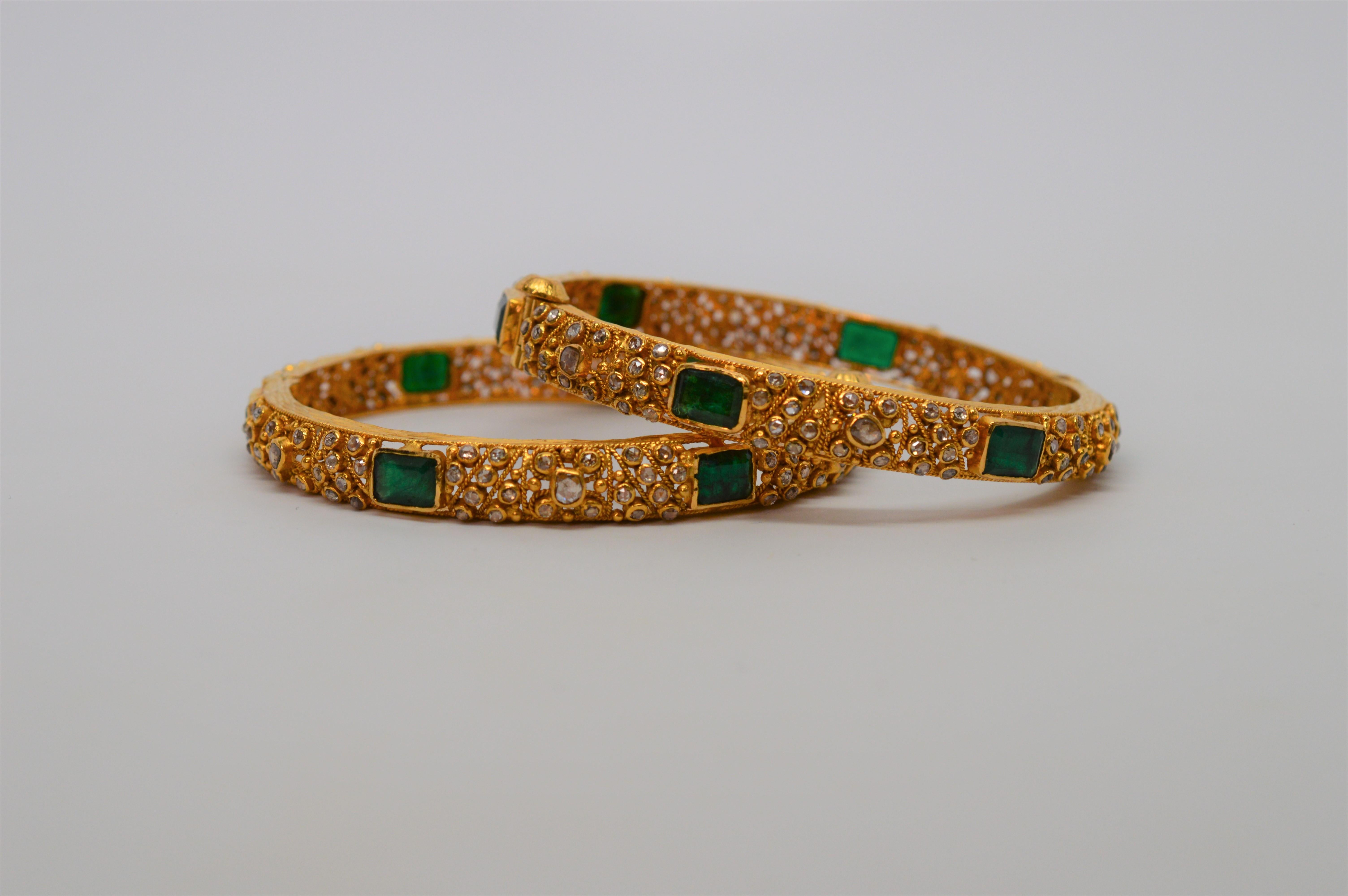 Made on the sub-continent of India in the late 1960's, this handmade matched pair of 22 Karat Yellow Gold Bangle Bracelets are expertly crafted with over four carats of natural rose-cut diamonds and approximately eleven carats of natural emeralds.