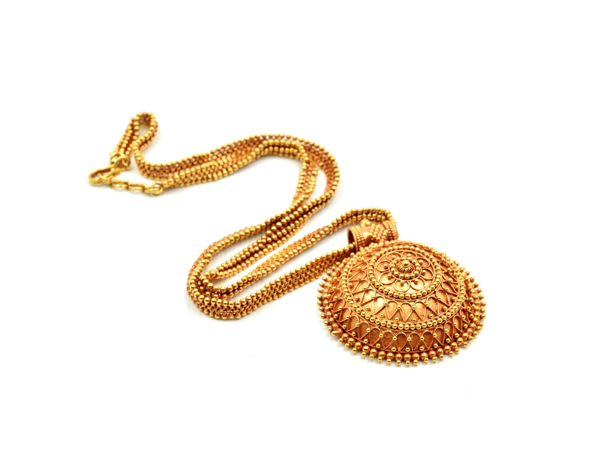 This 20” inch necklace is mounted with a beautiful India style domed pendant! The necklace and pendant are designed in 22k yellow gold with a granulated texture. The necklace consists of granulated 22k yellow gold beads in three rows, once the