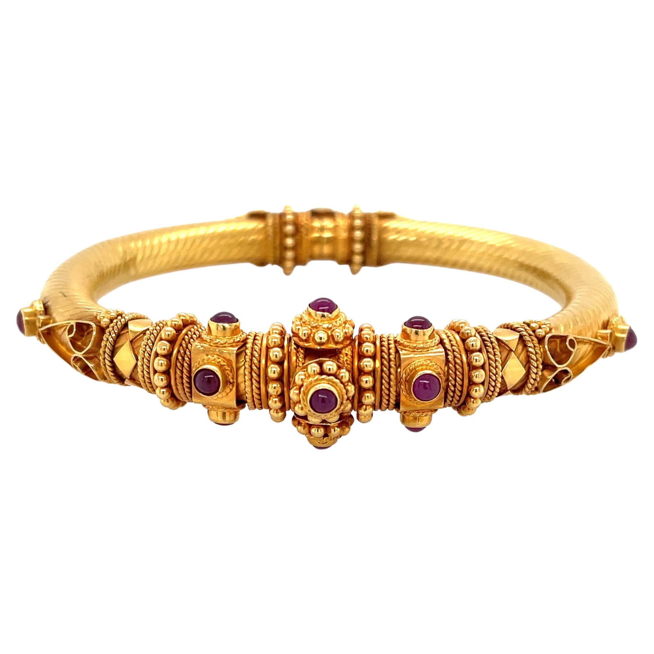Outstanding artisan hand-crafted work is displayed within the intricate Boho style design of this spectacular bangle bracelet made of  eighteen karat 18K yellow gold 
Natural ruby cabochon gemstones, .45 carat total weight accent this artful piece.