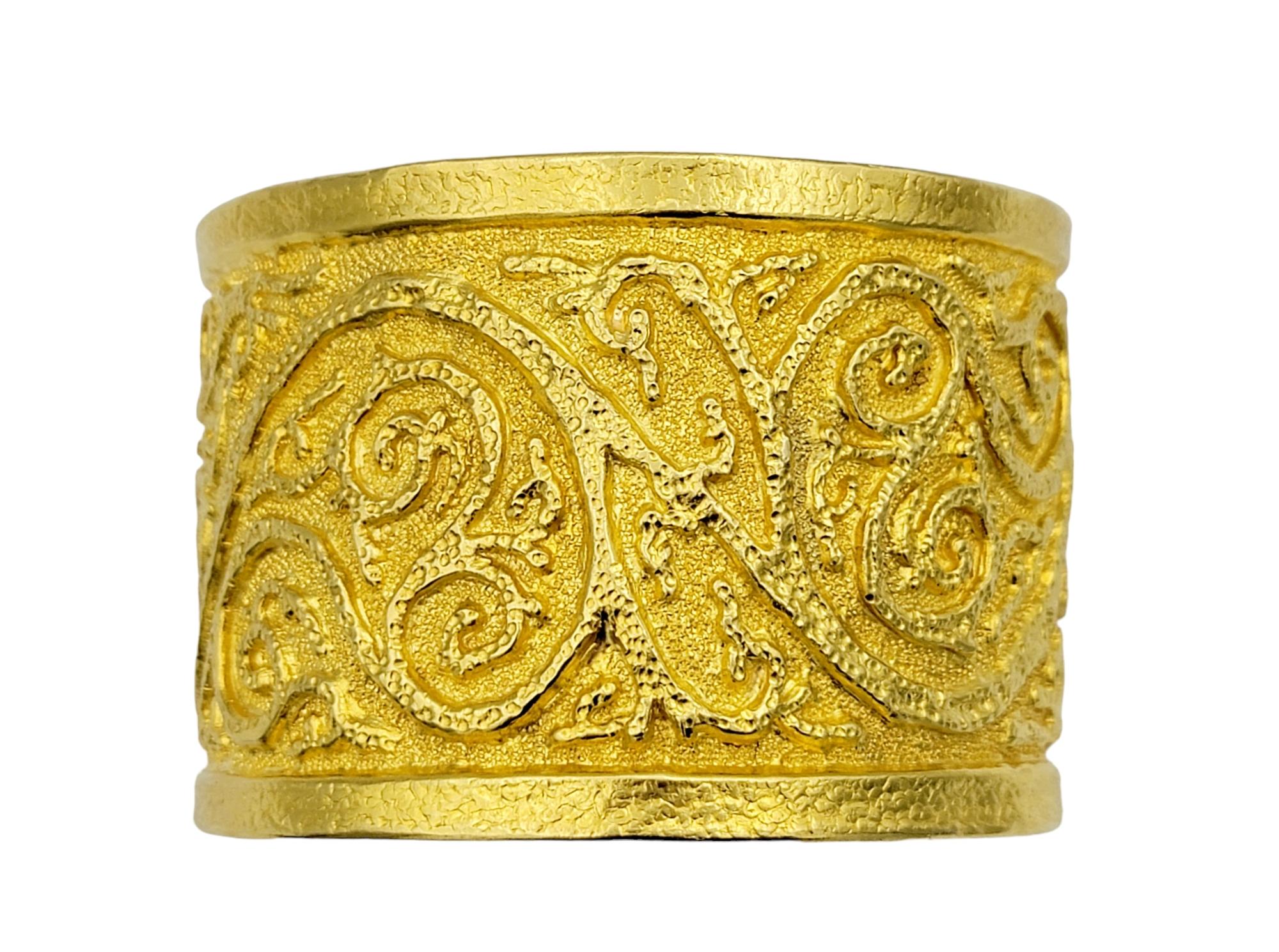 The inner circumference of this bracelet measures 7.25 inches and will comfortably fit up to a 7 inch wrist. 

Crafted from opulent 22 karat yellow gold, this wide cuff bracelet boasts an intricate scroll design that spans its entire surface. The
