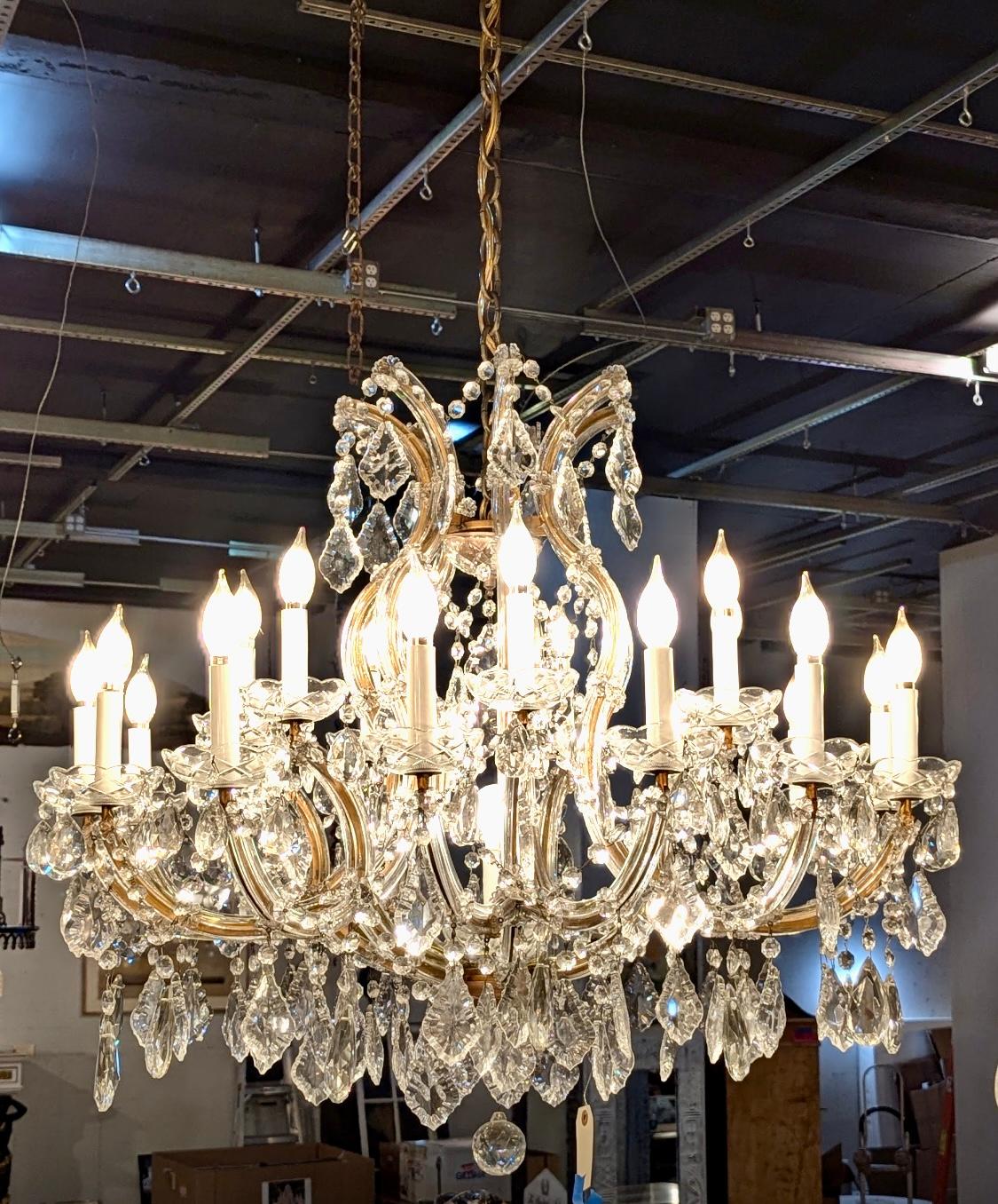 This UL listed chandelier has 22 E12 light sockets mounted with white plastic sleeved candlesticks and consists of numerous crystals hanging from beautifully curved arms covered in glass with attractive bobeches. The name for this style of
