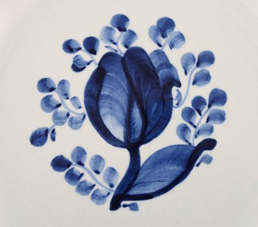 22 pieces. Cake plates, model number 11/944. Aluminia, Tranquebar. Light blue faience with dark blue tulip and braided rim by Christian Joachim.
Produced from 1914-1969, where it went to Royal Copenhagen.
Hand painted.
In very good