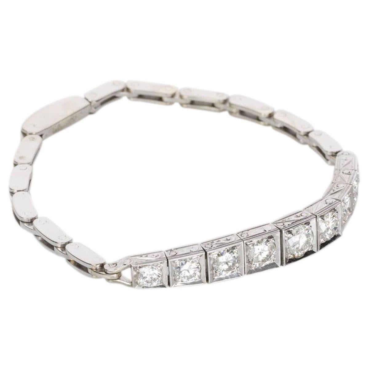 A beautiful bracelet that is great for everyday wear and will never go out of style. Set in the Art Deco fashion, this bracelet contains nine square grain set diamonds at the front with double row gate bracelet links to the back. The diamonds are