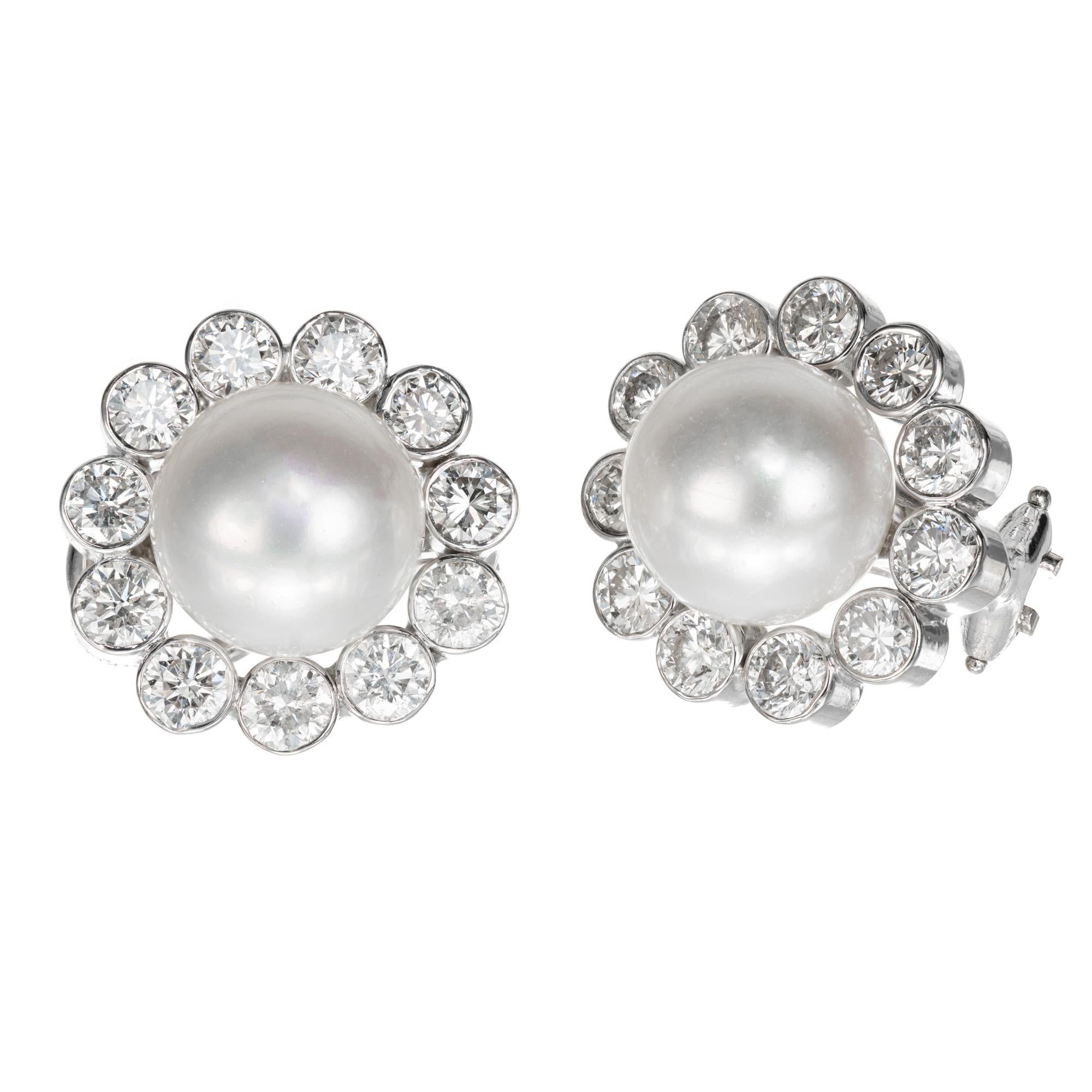 Pearl and diamond clip post earrings. 2 9.5mm Japanese cultured pearls, each with a halo of full ideal cut bezel set diamonds in 18k white gold button style settings. 

2 9.5 top gem Japanese cultured pearls with fine white high lustre. Pink