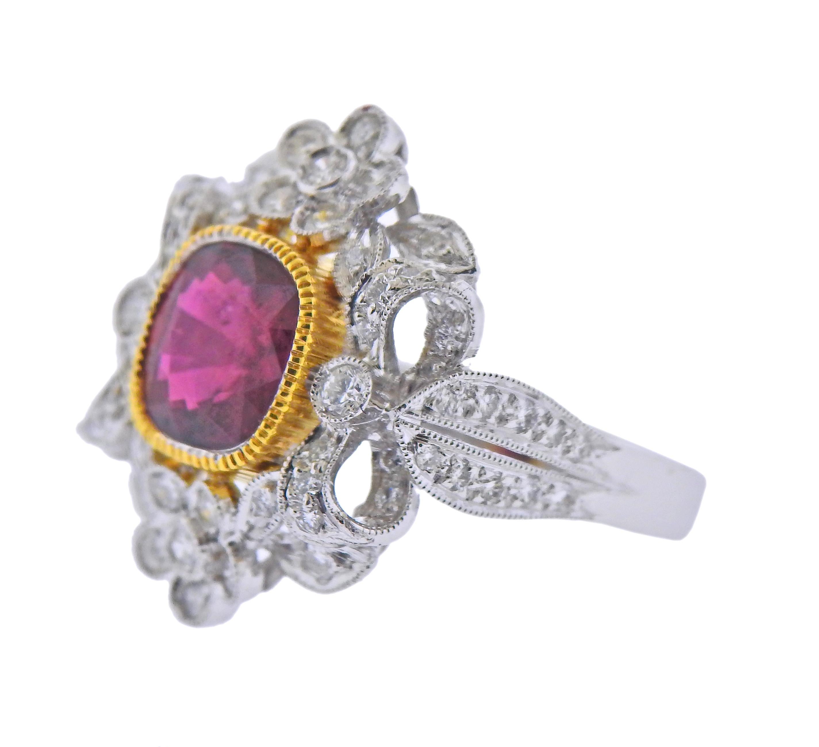 18k white and yellow gold ring with a center approx. 2.20ct ruby (measuring 8 x 7.6 x 4.1mm), surrounded with approx. 0.76ctw in diamonds. Ring size - 6.75, ring top - 21mm x 22mm. Marked 750. Weight - 7.9 grams. 