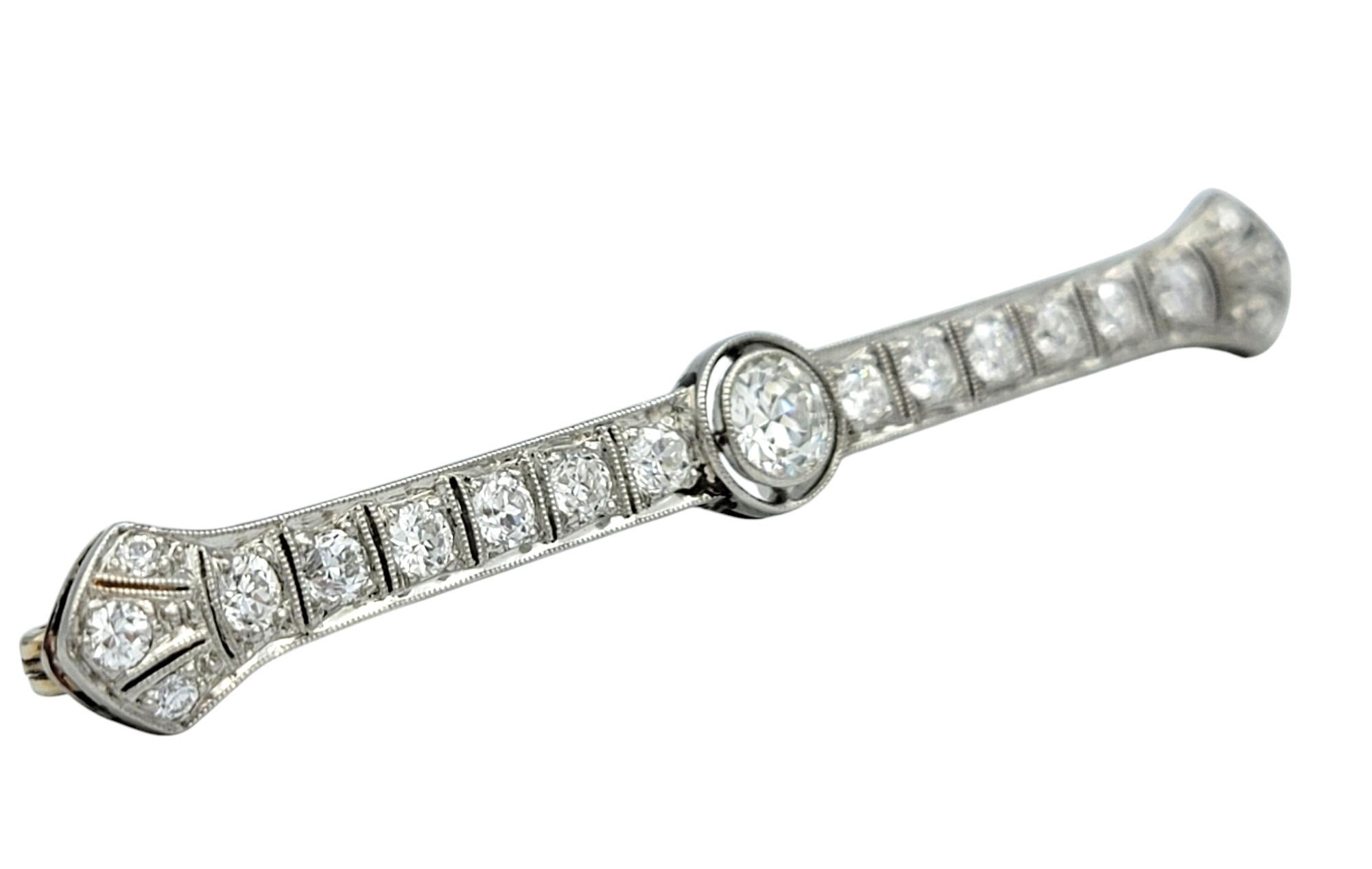 Lassen Sie sich von der Eleganz einer vergangenen Ära verzaubern - mit dieser diamantenen Brosche im Vintage-Stil, die durch ihre filigrane Handwerkskunst und raffinierte Schönheit besticht. Dieses exquisite Stück aus poliertem Platin hat ein