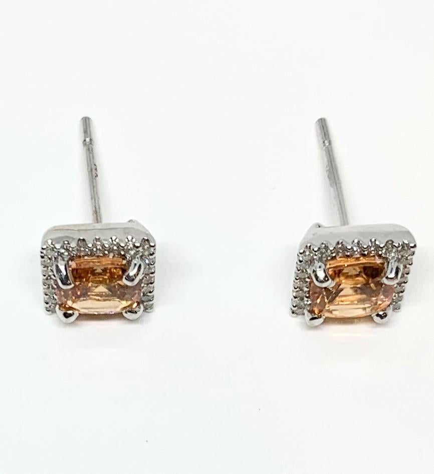 Fiery, Mandarin-orange spessartite garnets are featured in these pretty stud earrings. The gems are faceted square cushions and bordered by bright, brilliant cut diamonds, adding a little sunshine and sparkle to the day! Neutral enough to be worn
