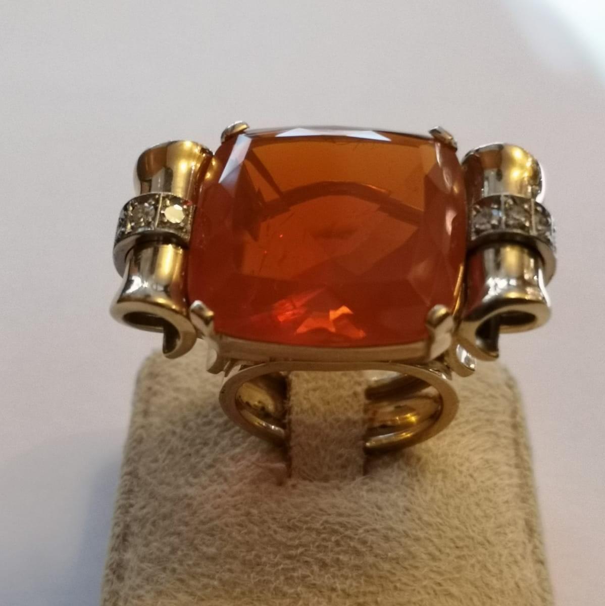 18 Kt Gold cocktail ring set with brilliant cut diamonds and Fire Opal.
Opal:  Ct. 22.00 Measure: mm 16.40X16.40
Diamonds: Ct. 0.35
Finger Size: 53