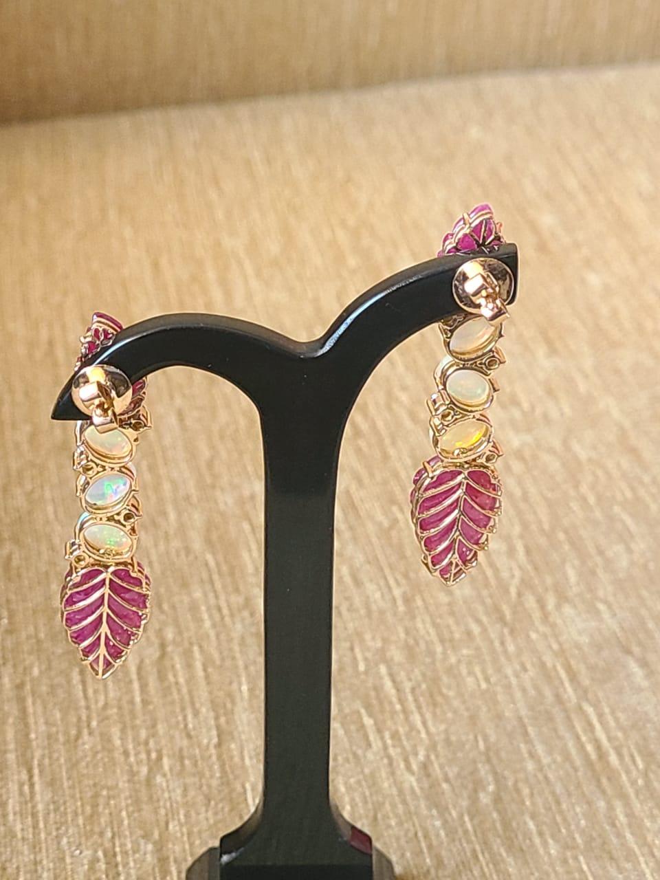 A very gorgeous and one of a kind, Ruby & Opal Chandelier/ Dangle earrings set in 18K Gold & Diamonds. The weight of the Rubies is 22.04 carats. The Rubies are of Mozambique origin and are completely natural, without any treatment. The Rubies are
