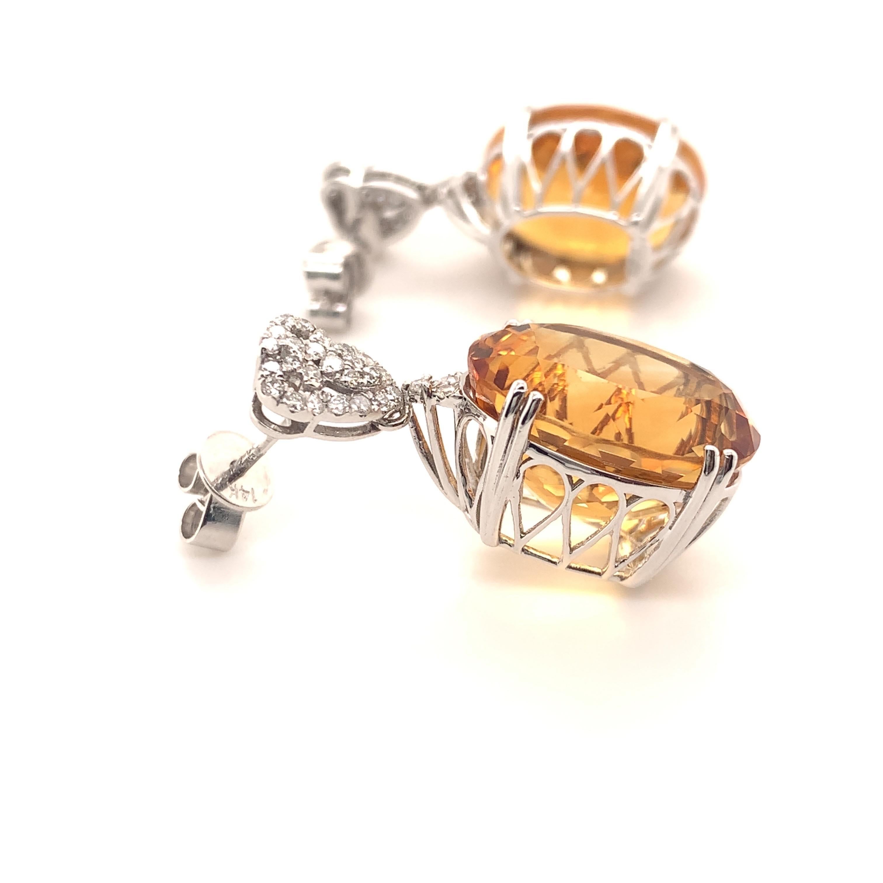 Stunning dangling citrine diamond earrings. High brilliance, golden honey tone, transparent clean, oval faceted natural 22.07 carat citrine mounted in an open basket with 8 bead prongs, accented with round brilliant cut diamonds. Handcrafted design