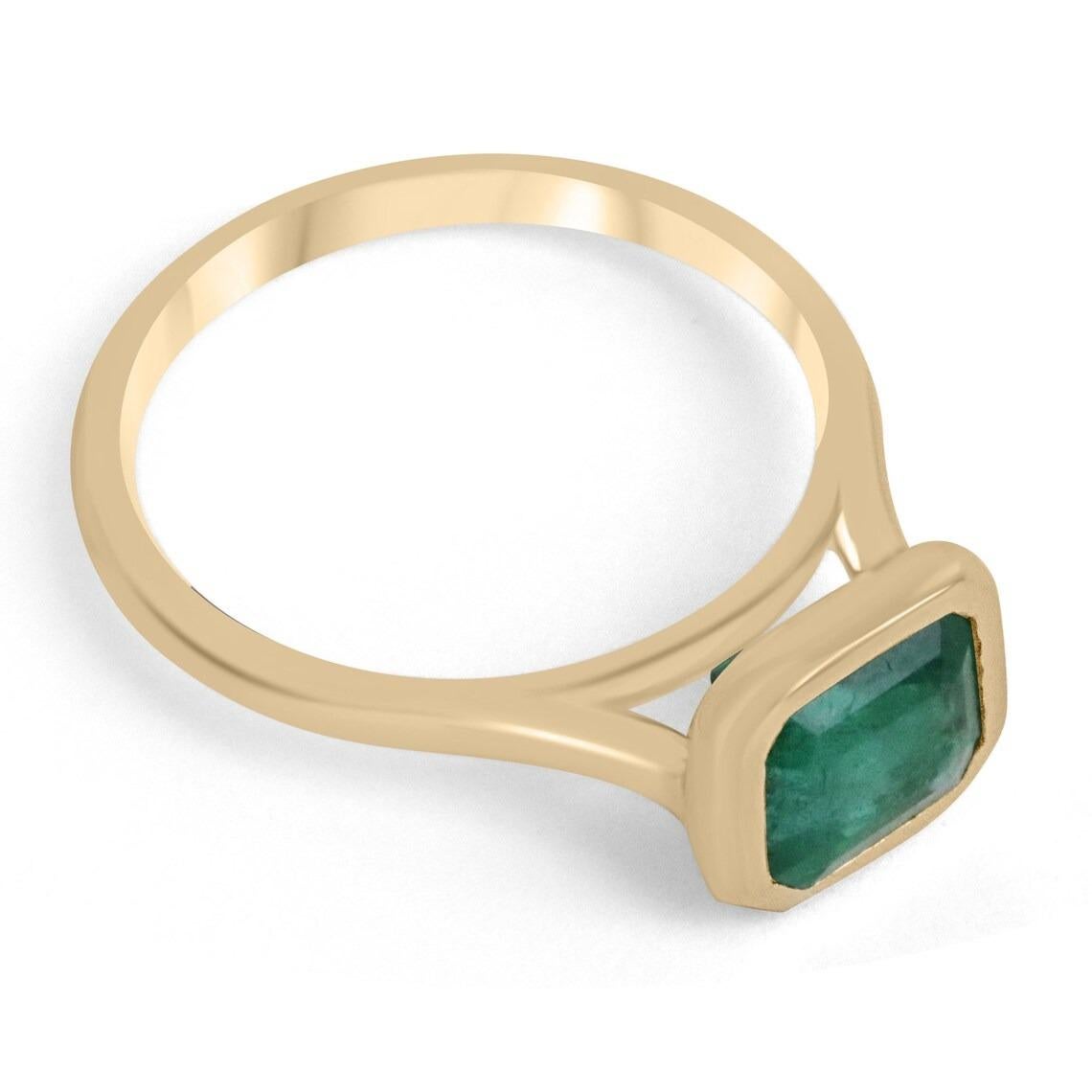 Displayed is a magnificent solitaire emerald engagement or right-hand ring. This lovely piece showcases an impressive 2.20-carat, natural emerald from the origin of Zambia. This mesmerizing stone has the most beautiful and desirable dark forest