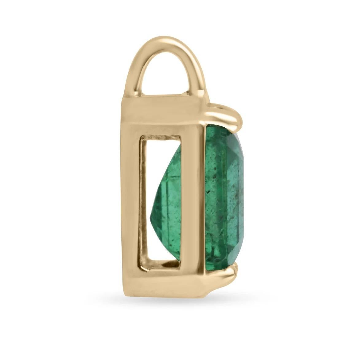 Featured here is a stunning emerald cut Zambian emerald necklace in fine 14K yellow gold. Displayed in the center is a dark-green emerald with very good clarity, accented by a simple four-prong gold mount, allowing for the emerald to be shown in