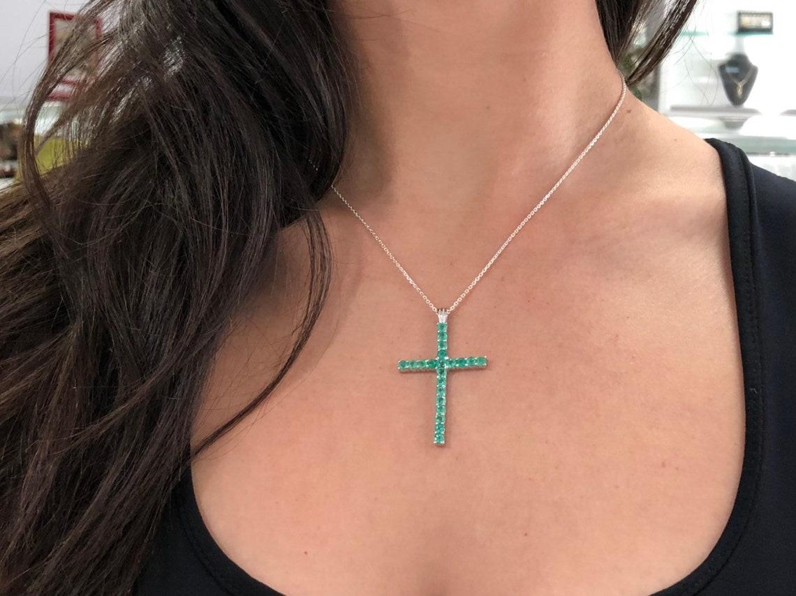 A token of faith, a symbolic emerald cross. This pendant features numerous, bluish-green emerald prong-set in a simple yet beautiful design. This piece is ideal for a gift. Each emerald was hand-selected by Jorge Rodriguez.

Gold: 14K White, Yellow