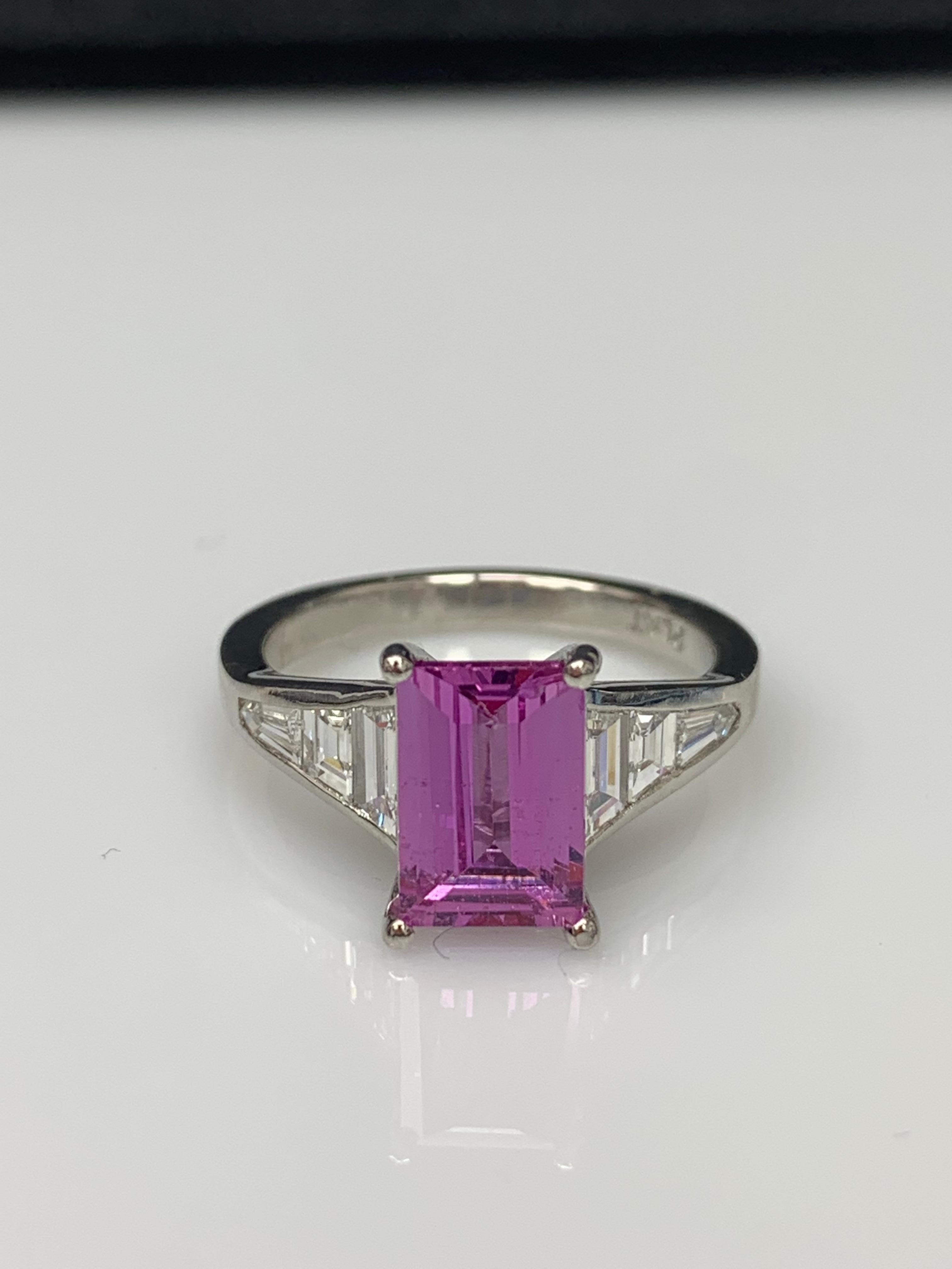 A stunning well-crafted engagement ring showcasing a 2.21-carat Cushion Cut Pink Sapphire. Flanking the center diamond are perfectly matched graduating step-cut diamonds, channel set in a polished platinum mounting. 6 Accent diamonds weigh 0.76
