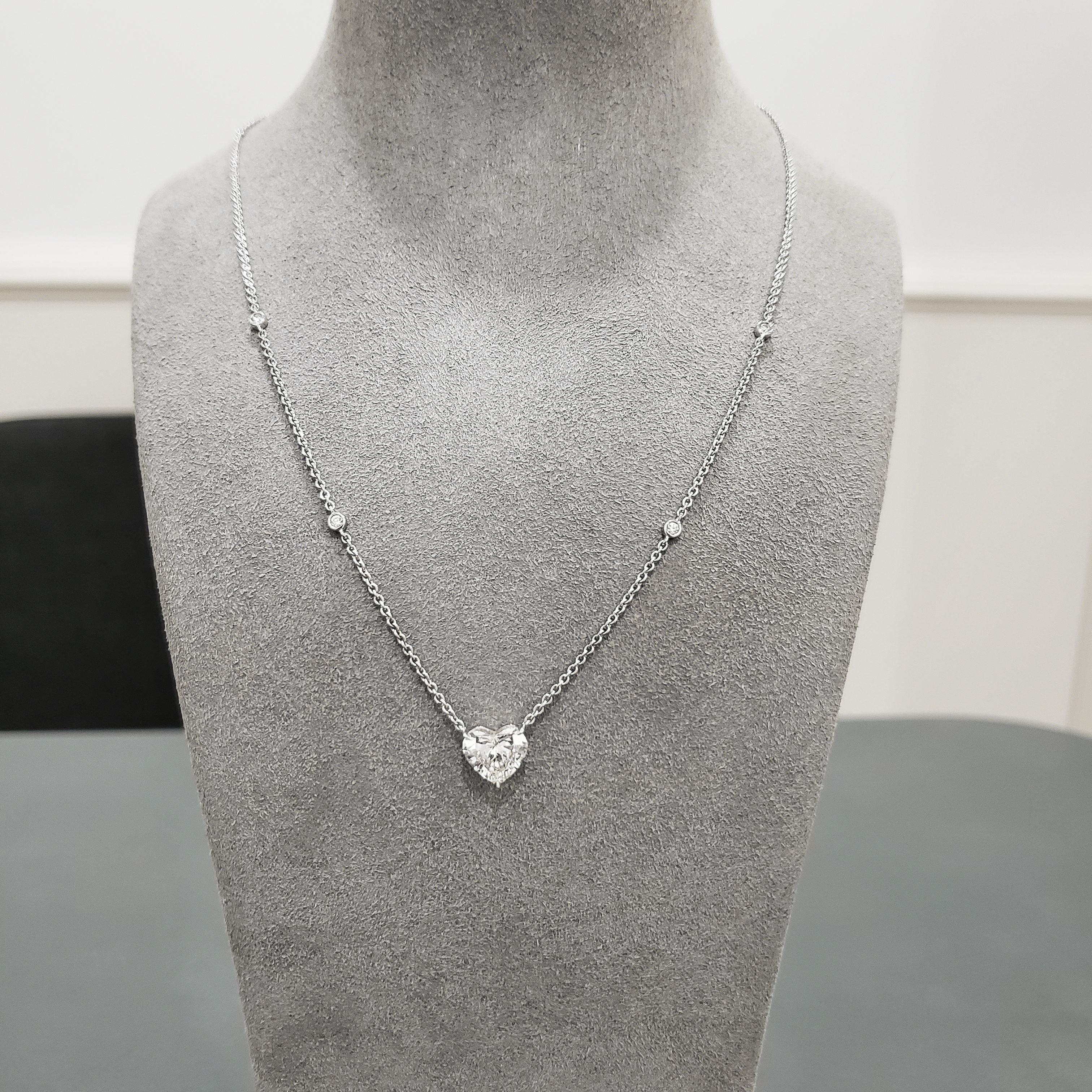 A unique solitaire pendant necklace showcasing a single heart shape diamond weighing 2.21 carats, suspended on a 16 inch white gold chain accented with four round brilliant diamonds. Accent diamonds weigh 0.17 carats total. 

Style available in