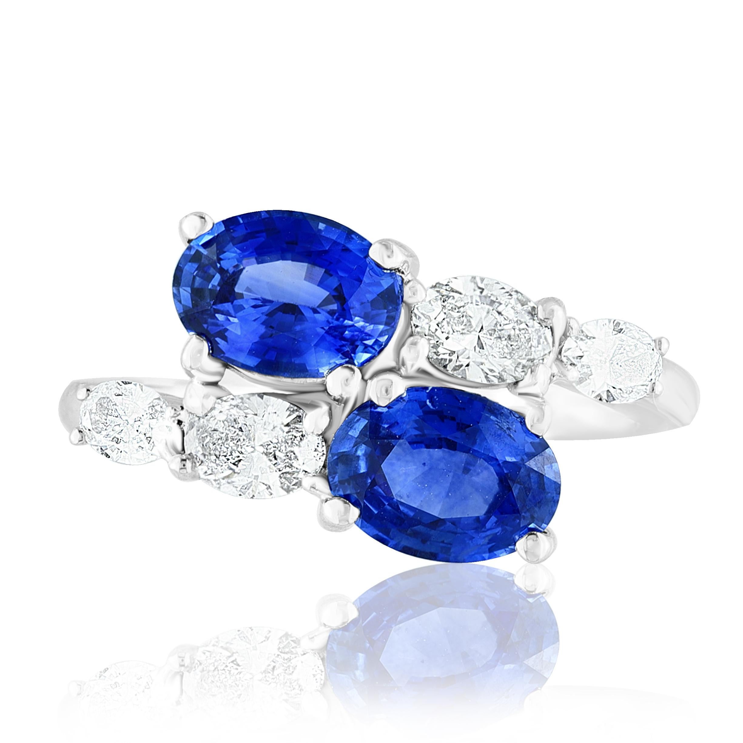 Der atemberaubende Ring Toi et Moi für die Ewigkeit zeigt 2 blaue Saphire im Ovalschliff, die von 4 ovalen Diamanten in Ost-West-Richtung umrahmt werden. Handgefertigt aus 14k Weißgold.
2 ovale blaue Diamanten in der Mitte wiegen 2,21 Karat und 4