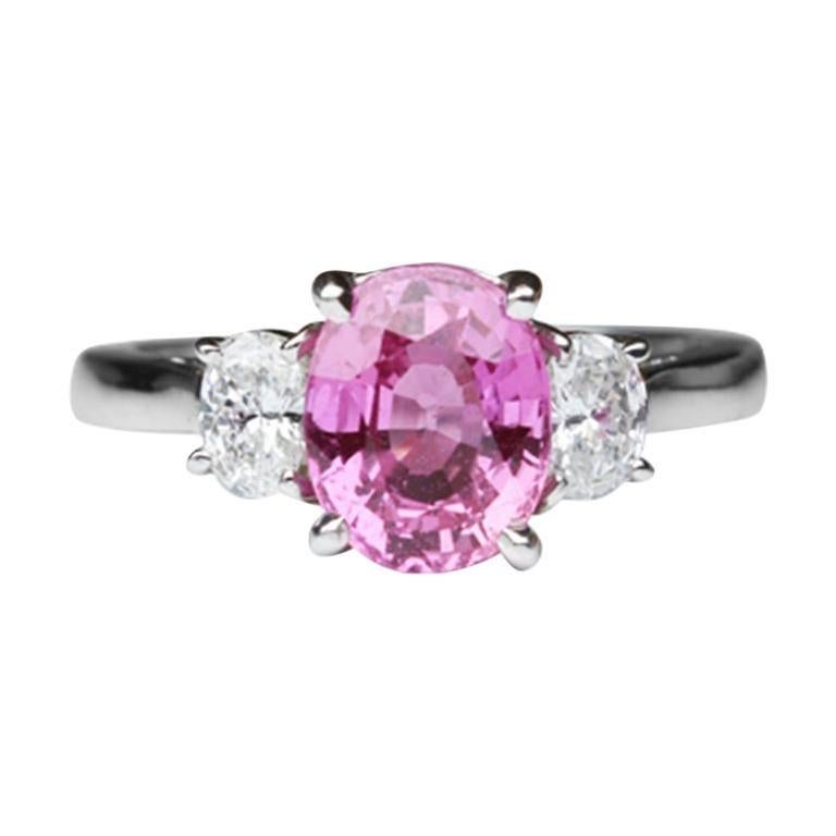 Elegant & finely detailed Solitaire Cocktail Engagement Ring, set with a securely nestled 2.21 Carat Intense Pink oval Sapphire, clarity: VS; internally flawless (IF); dimensions: 8.3mm x 6.7mm, either side set with Brilliant-cut Diamonds, measuring