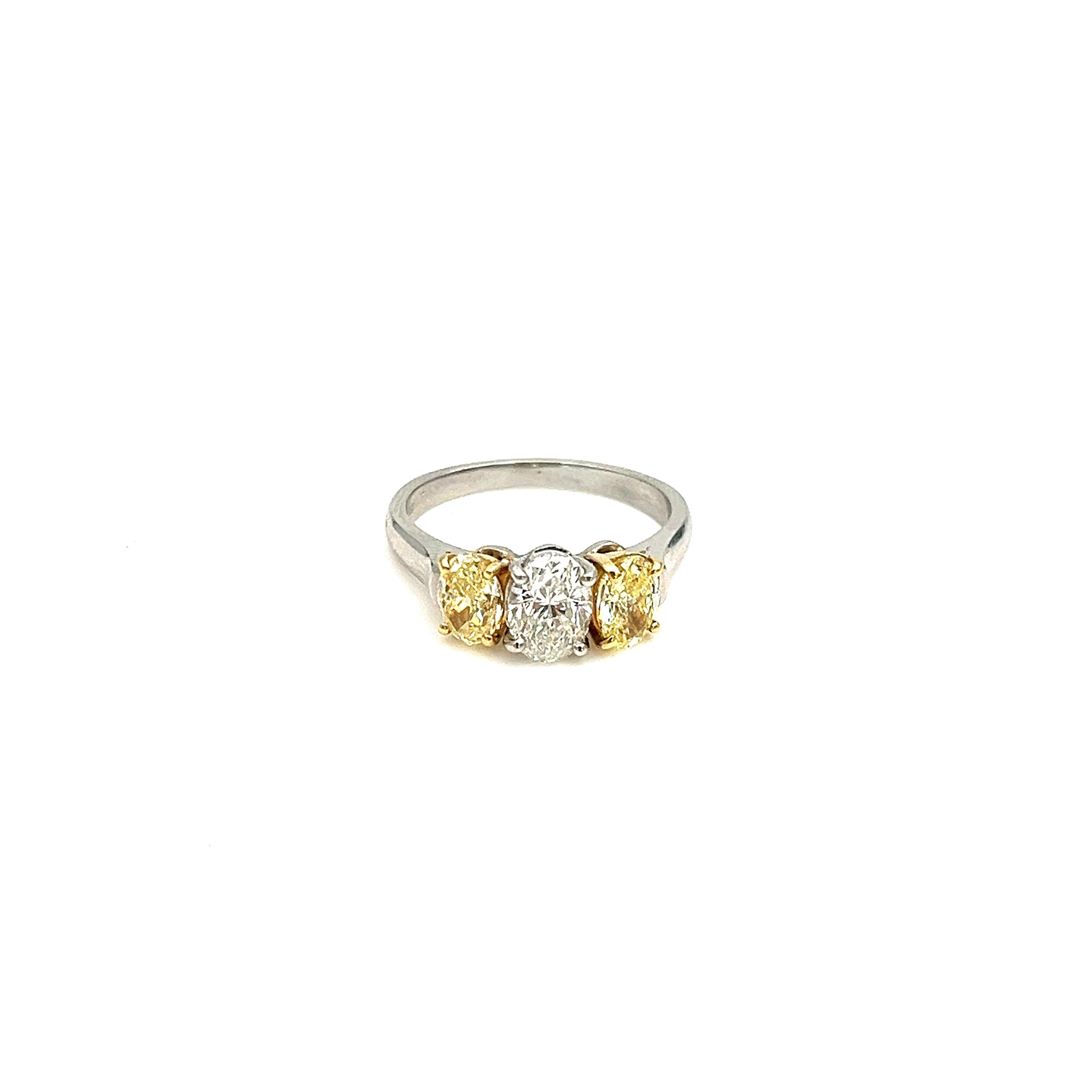 This stunning 2.21-carat three-stone yellow and white diamond ring is the perfect addition to any jewelry collection. The center stone is a beautiful natural yellow diamond weighing .96 Fancy intense yellow accompanied by GIA.  The ring is
