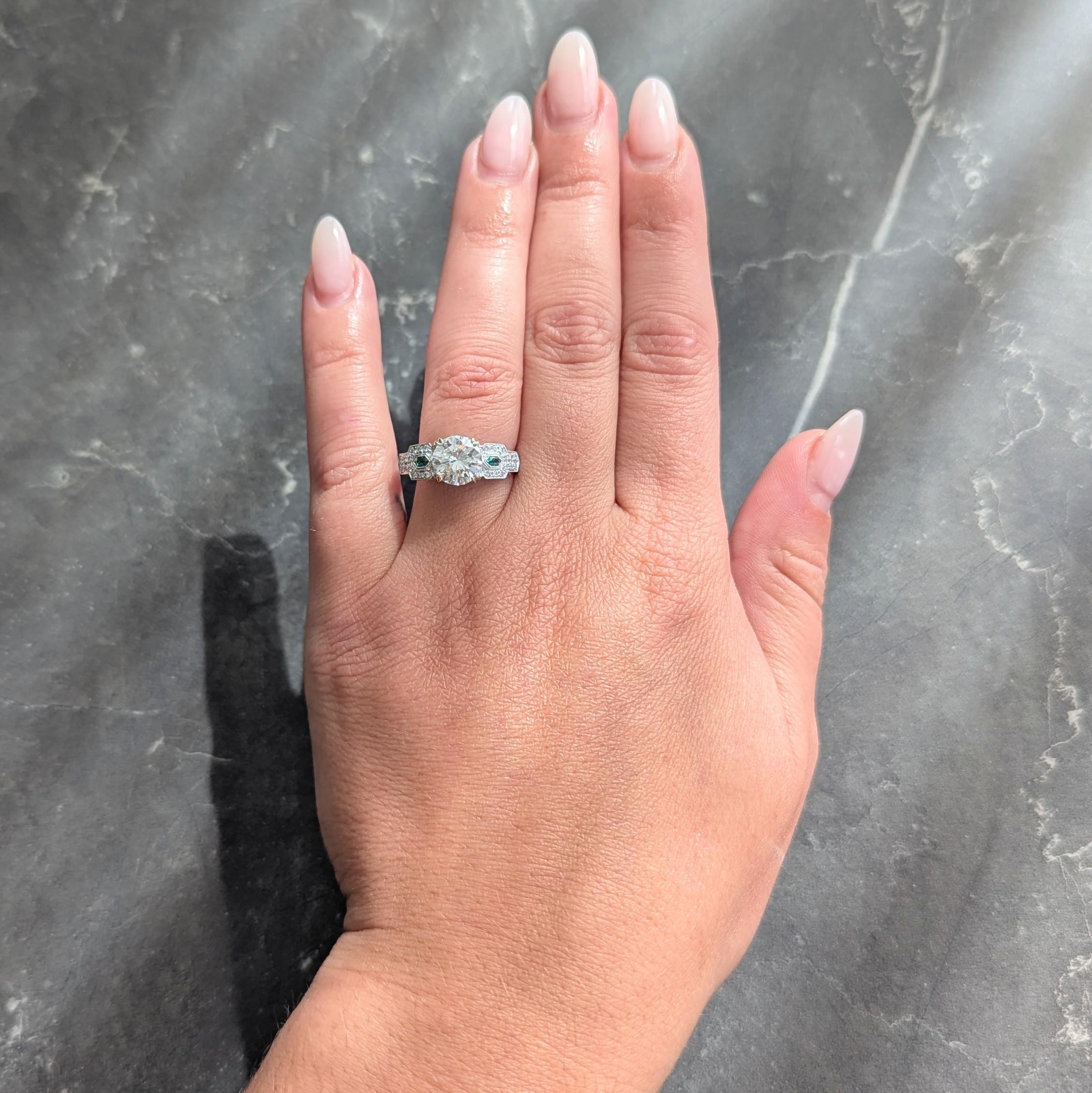 In der Mitte ein Diamant im alten europäischen Schliff mit einem Gewicht von 1,83 Karat - Farbe I und Reinheit SI1
Mit gespaltenen Zacken in einem stilisierten Korb und flankiert von Smaragden im Sechseckschliff besetzt
Mit einem Gesamtgewicht von