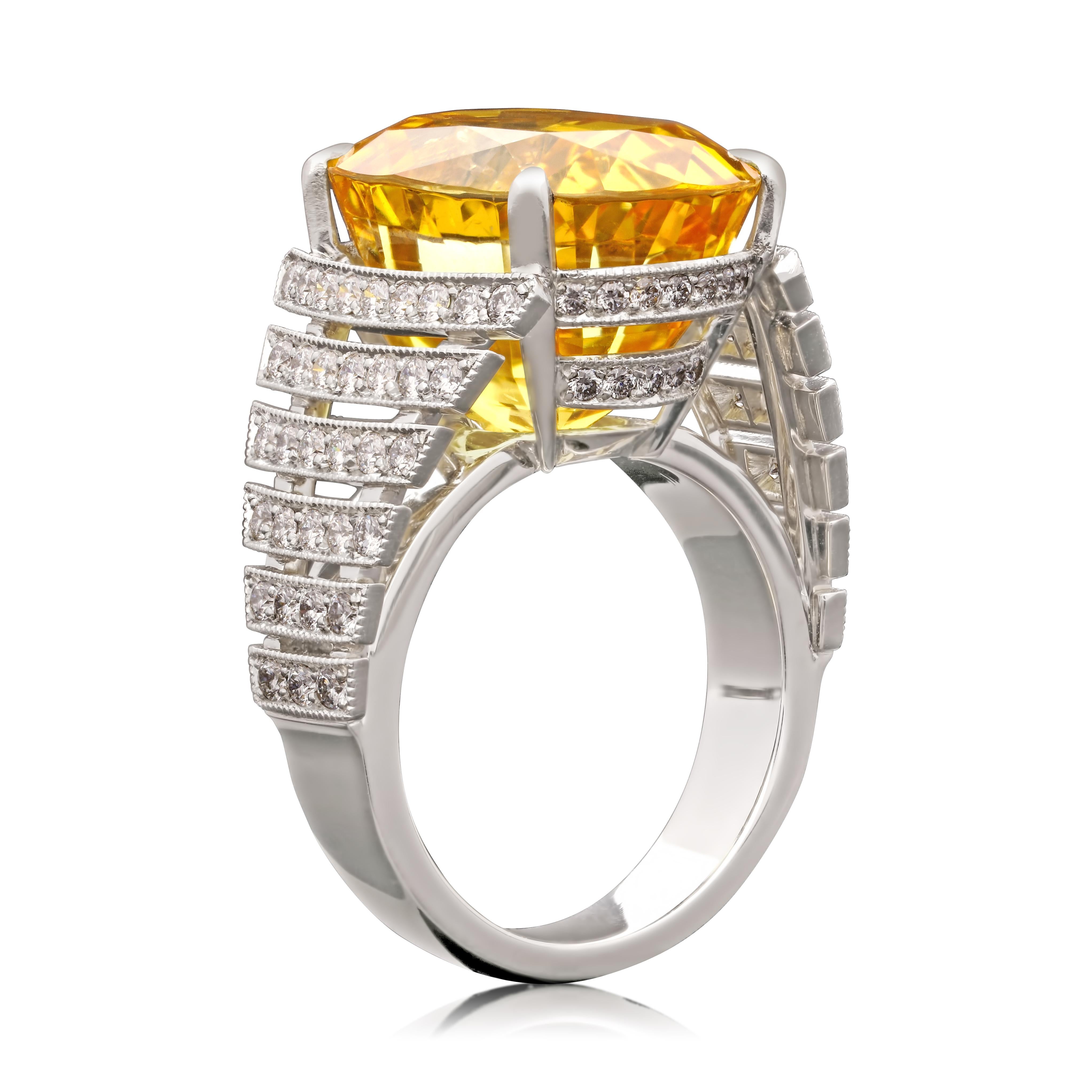 A stunning yellow sapphire and diamond ring by Hancocks, centred with a beautiful cushion shaped Ceylon sapphire of rich golden yellow colour, weighing 22.13ct and certified unheated, set in a finely crafted handmade openwork platinum mount with six