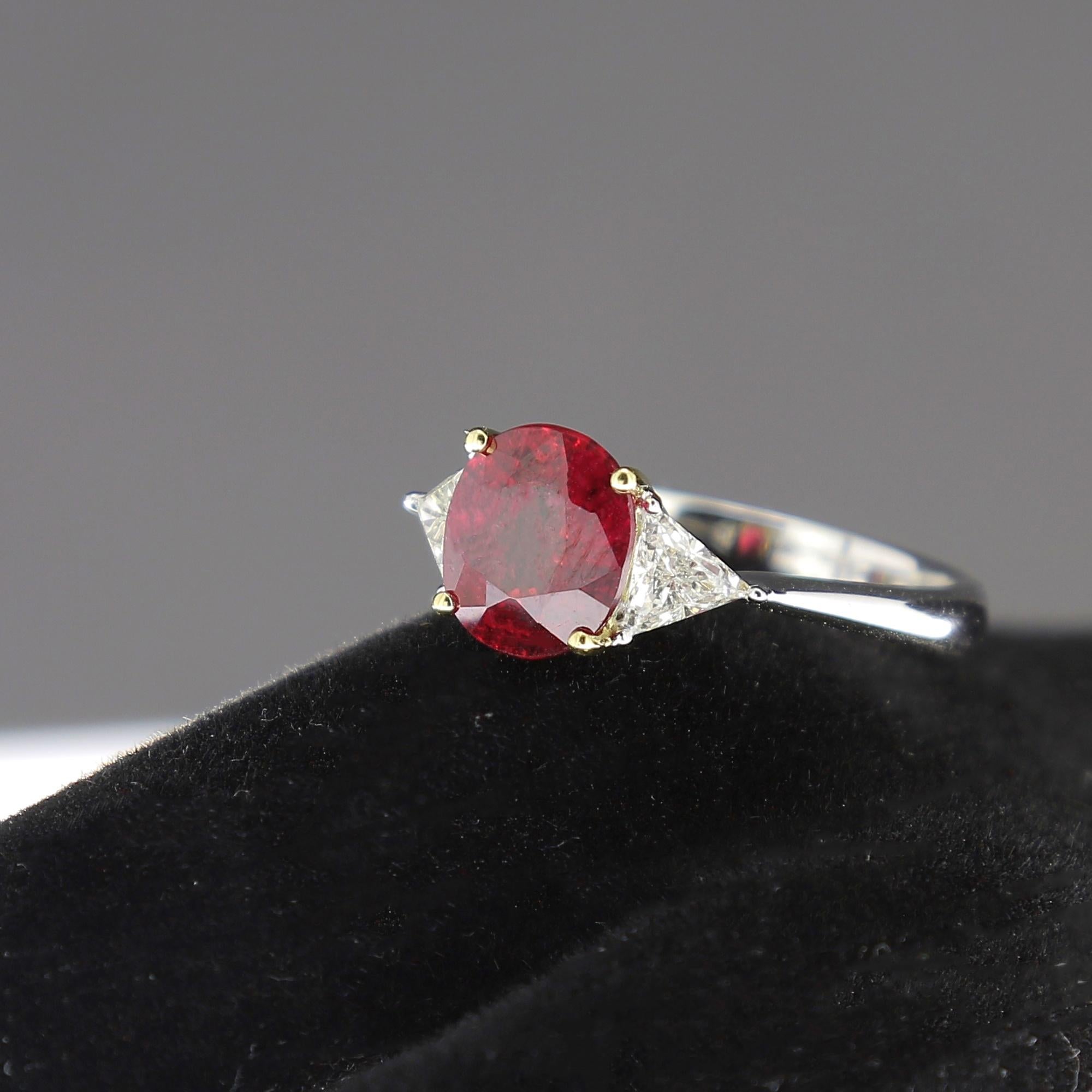 An amazing cushion ruby ring, flanked on each side by a single trillion-cut diamond (also called 