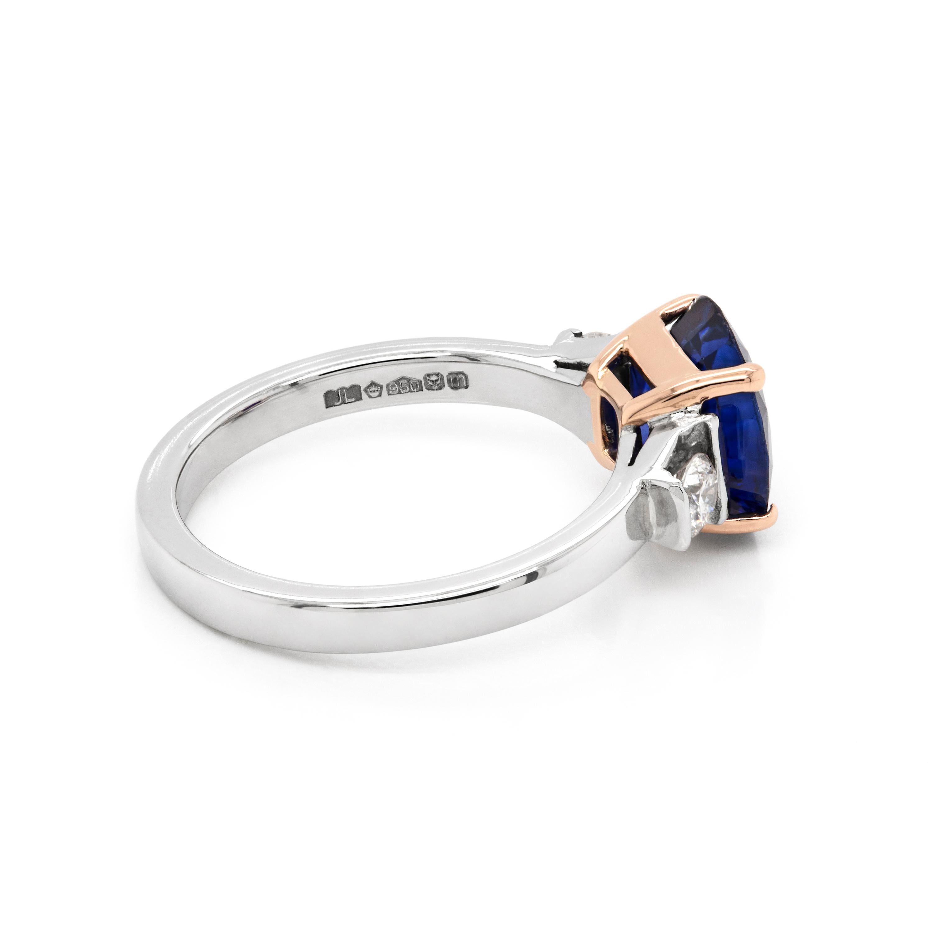 Dieser wunderschöne Ring mit drei Steinen besteht aus einem runden königsblauen Saphir von 2,22 Karat, der in eine 18-karätige Roségold-Spange mit vier Klauen eingefasst ist. Der Edelstein wird von einem runden Diamanten im Brillantschliff mit einem