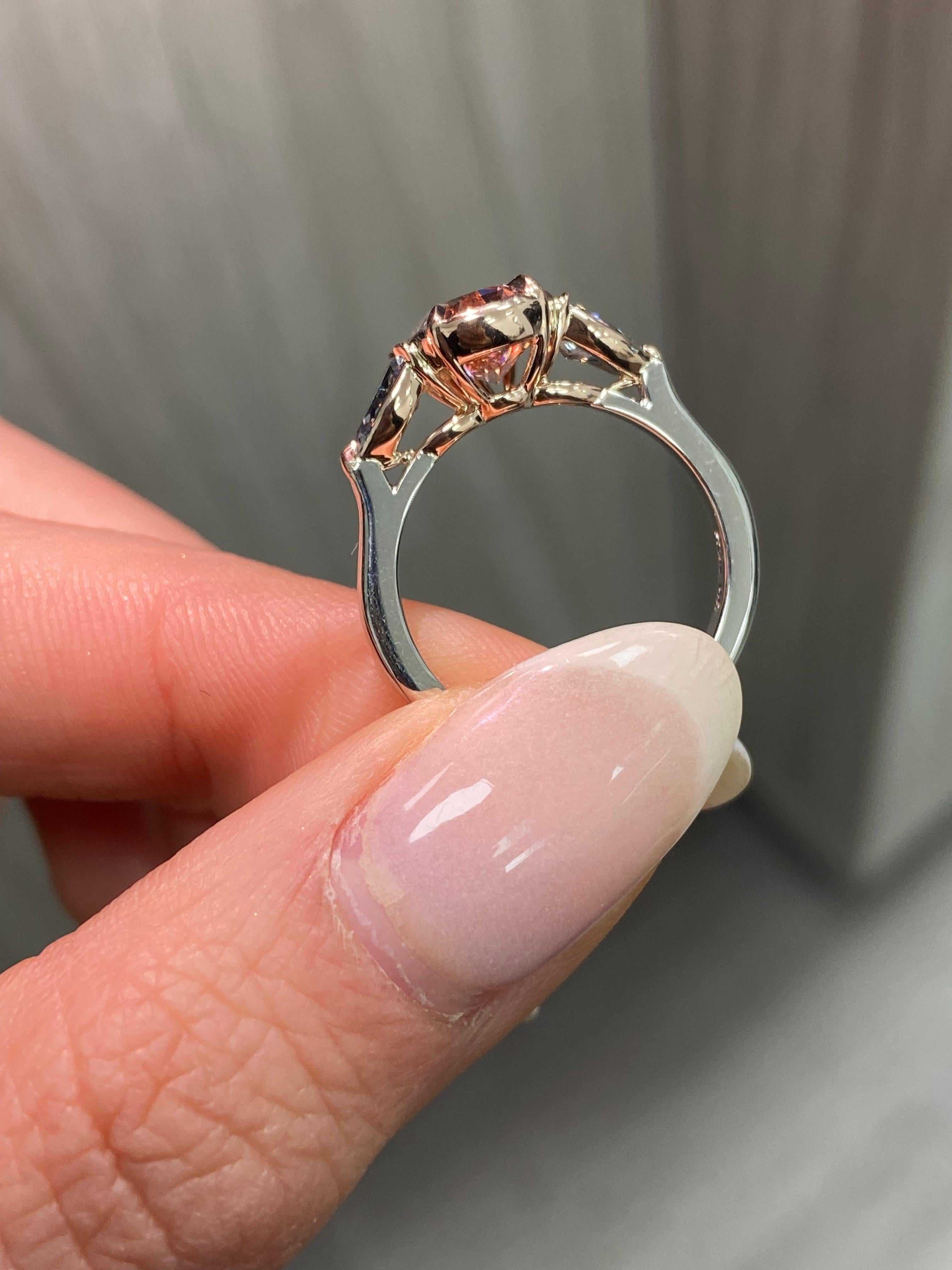 This extraordinary ring is a celebration of nature’s rarest and most vibrant treasures, brought together in a masterpiece of design and craftsmanship. At its heart lies a 2.22-carat fancy deep brown-pink pear-shaped diamond—one of the highest color