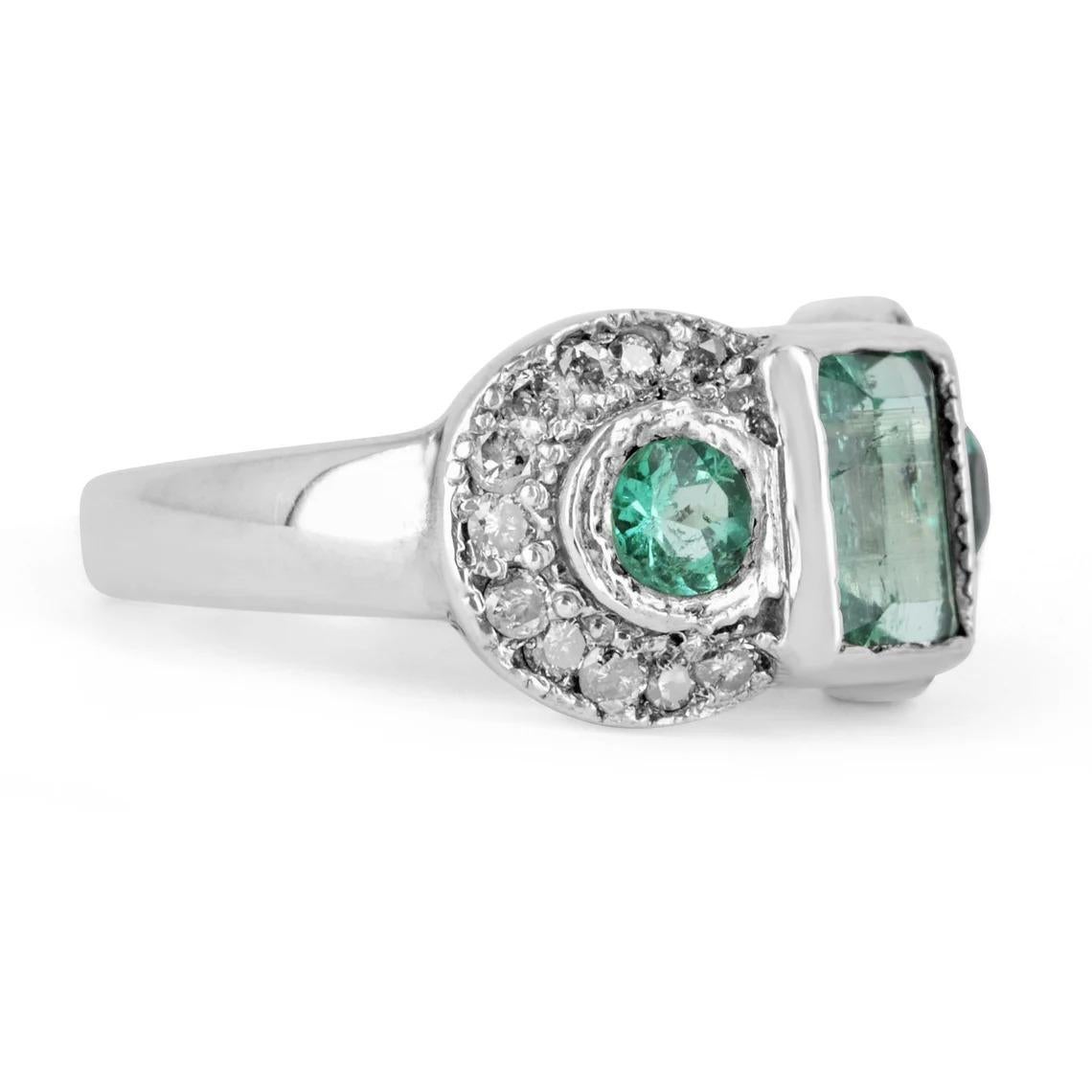 Displayed is a 2.22tcw vintage Colombian emerald and diamond ring. This is a perfect, three-stone statement ring. The emeralds are of good, varying quality and are handset in a 14K white gold bezel setting. The bluish-green color is only recognized