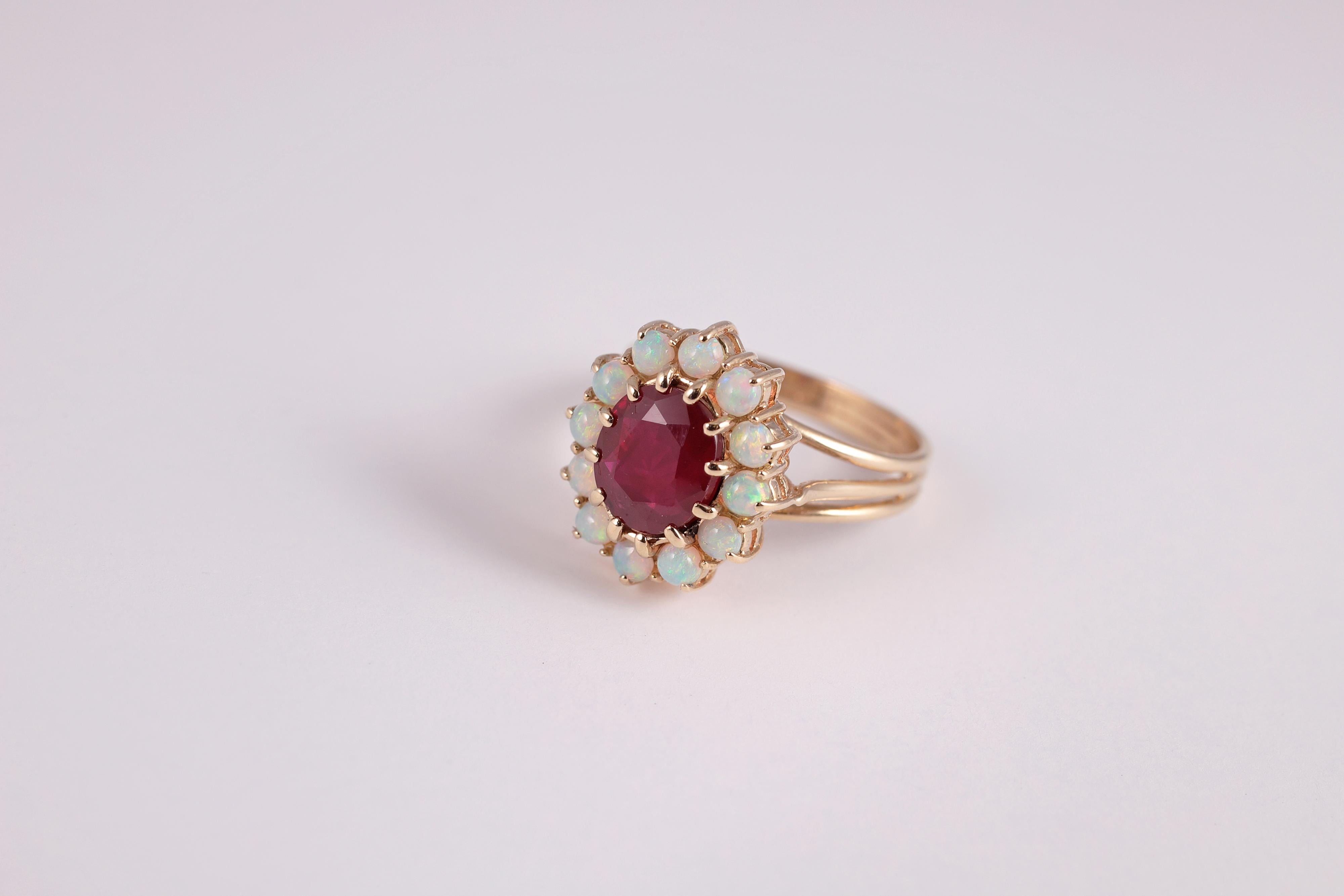 Sure to impress!  This 2.23 carat untreated Burma ruby and opal halo ring is in 14 karat yellow gold. 
Size 6 3/4.
Accompanied by Stone Group Lab Identification Report stating the following:
Species:  Corundum
Variety:  Ruby
Cut:  Oval
Size:  8.09