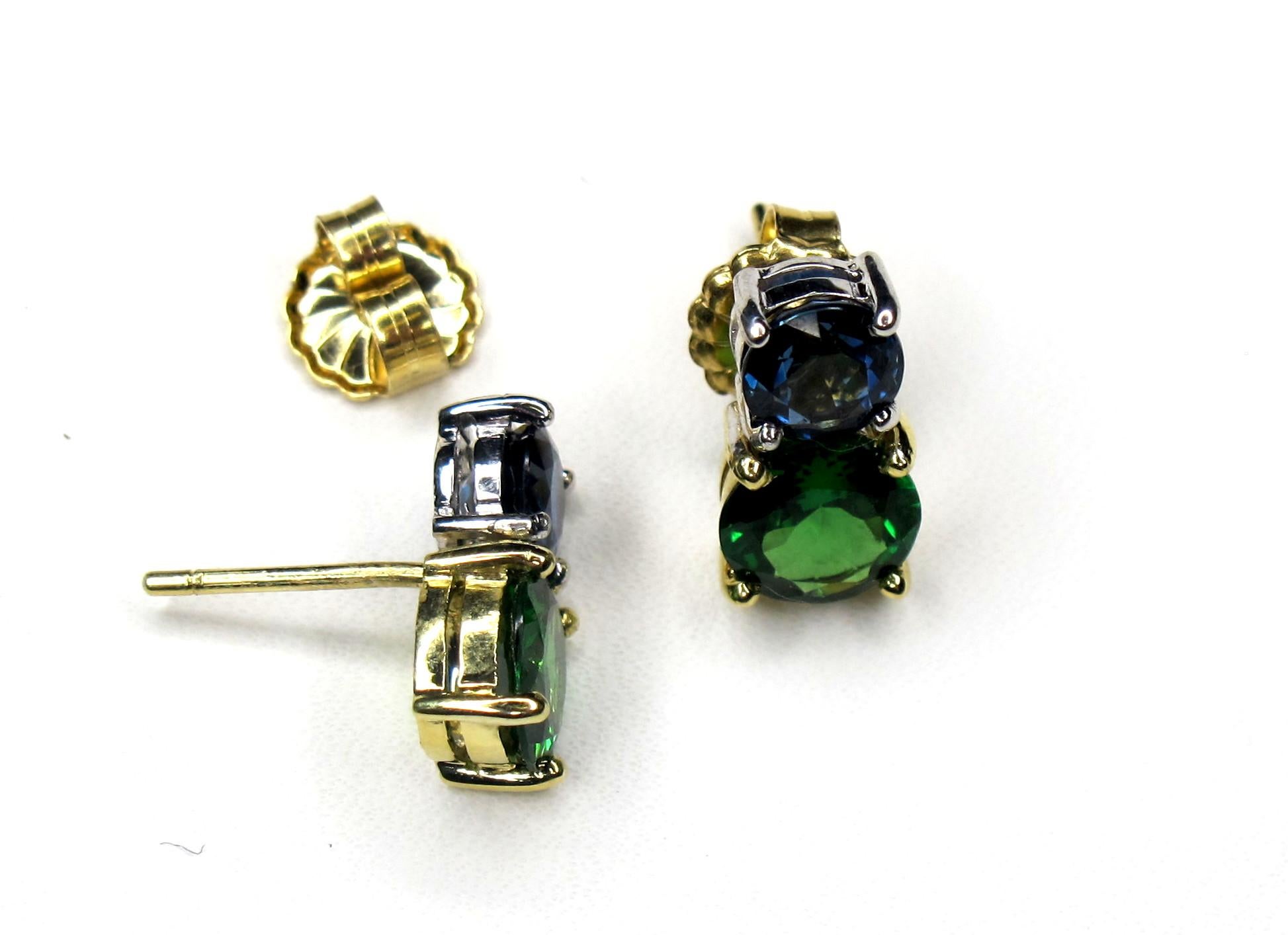 These color-blocked stud earrings are timeless in design but with a modern twist of contemporary color! Two large, matching green tsavorite garnets are paired with two matching blue sapphires to form these unique earrings. The emerald-green color