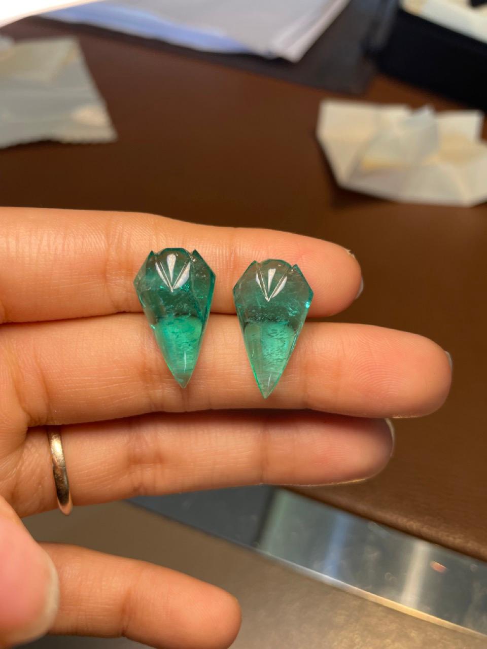ntroduciamo un'affascinante coppia di smeraldi cabochon dello Zambia, dalla splendida forma di delicati boccioli, con un peso complessivo di 22,35 carati. Queste squisite gemme mostrano le lussureggianti e vibranti sfumature verdi per cui gli