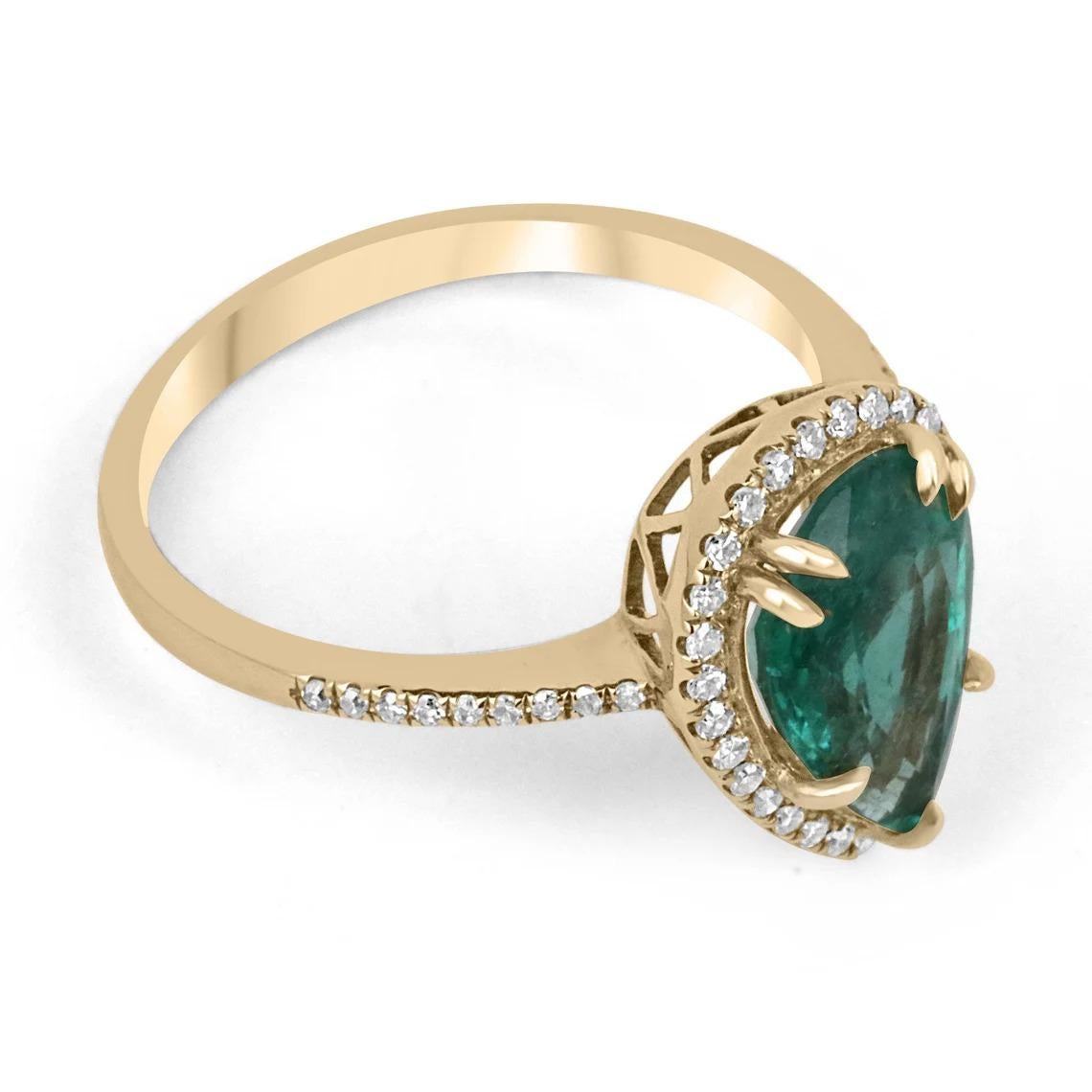 A ravishing emerald and diamond halo right-hand/engagement ring. This striking piece features a stunning pear-cut emerald from the natural origin of Zambia. The gemstone displays an alluring bluish-green hue with its natural medium green color. Very