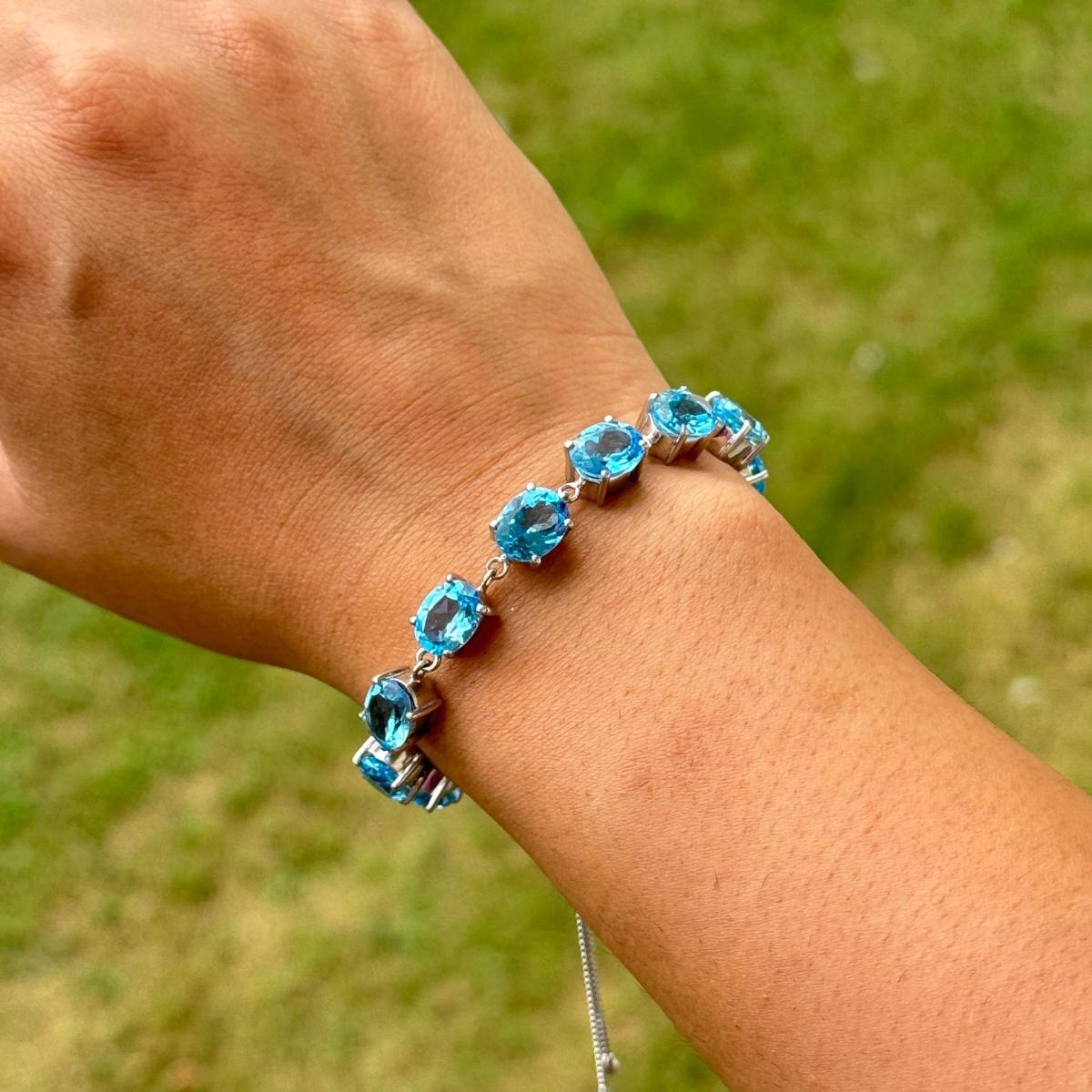 Questo bracciale bolo regolabile in argento con topazio blu naturale da 22,45 carati è uno splendido bracciale bolo in argento sterling 925, ornato da una graziosa linea di gemme di topazio blu di taglio ovale. Ogni gemma irradia un'accattivante