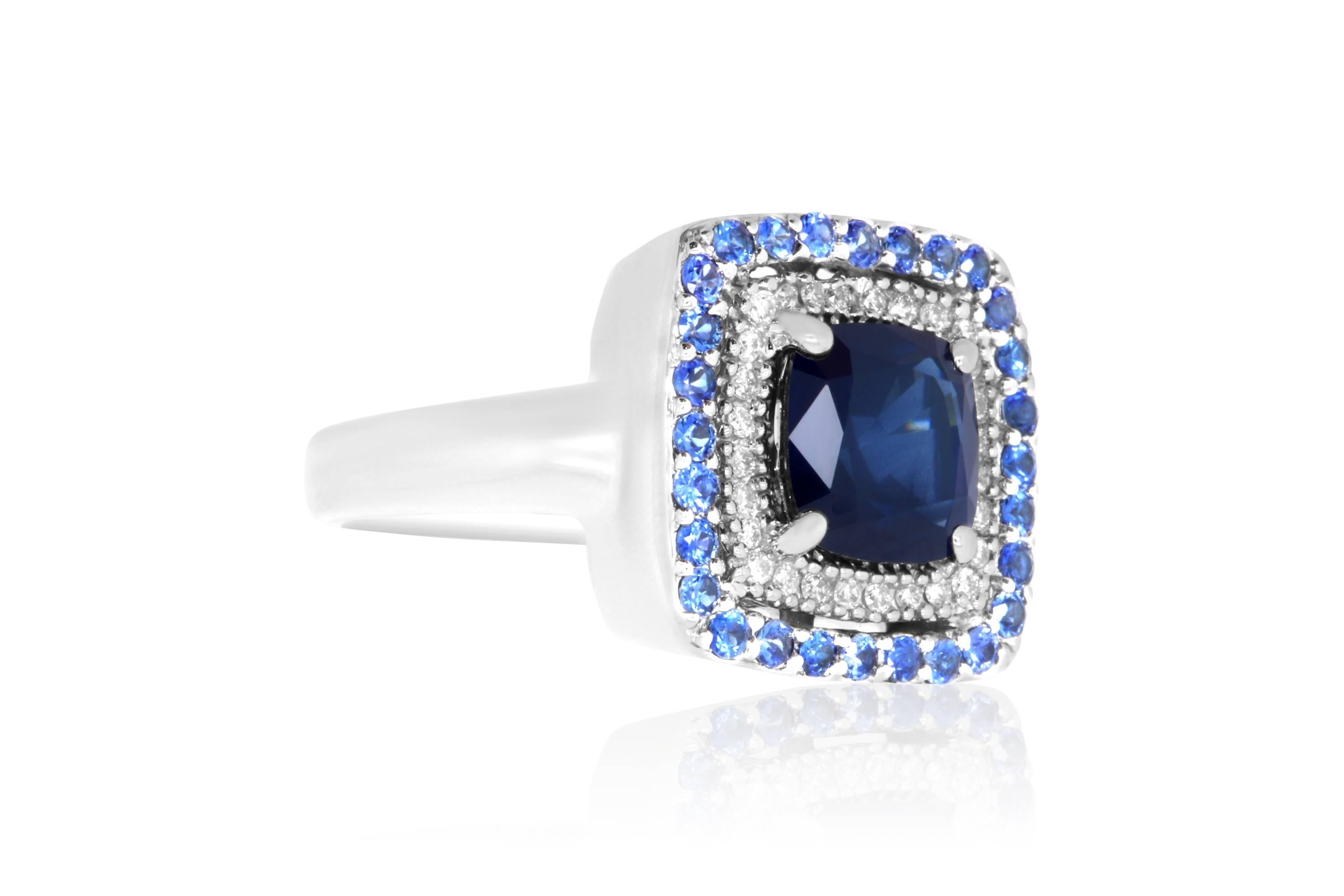 Material: 14k White Gold 
Center Stone Details: 1 Cushion Cut Blue Sapphire at 2.25 Carats - 7mm
Mounting Details: Brilliant Round White Diamonds at 0.10 Carats. Clarity: SI / Color: H-I. 
28 Round Blue Sapphires at 1.20 Carats.
Ring Size: Size 5.25