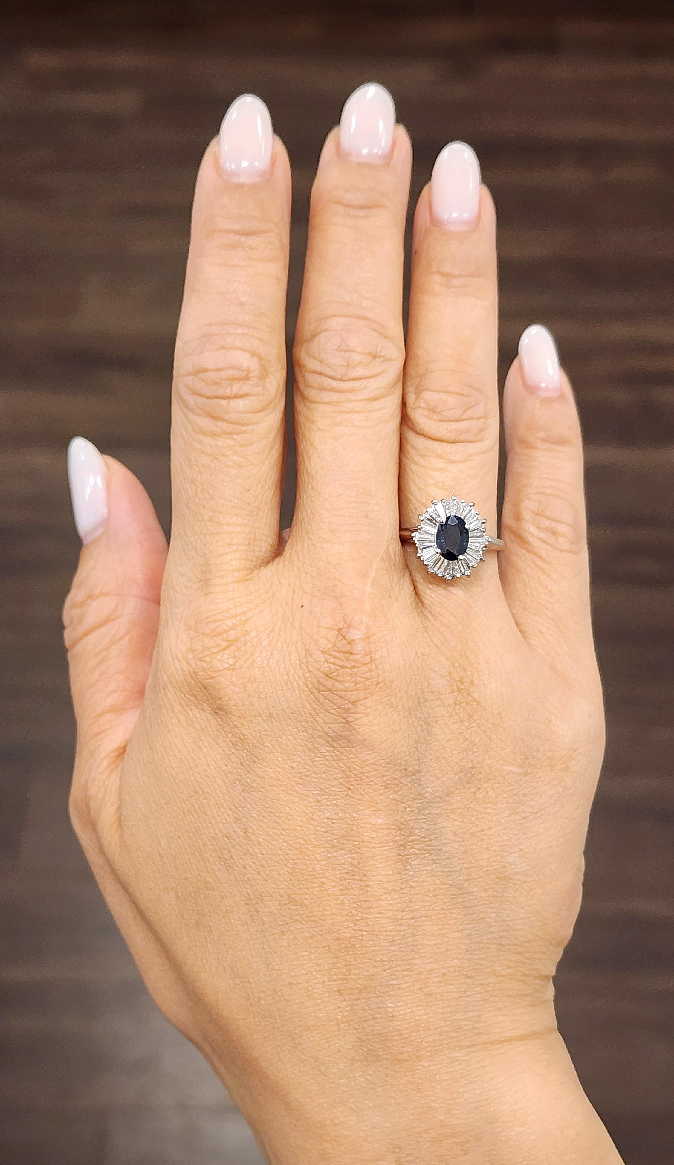 Questo moderno anello di moda sfoggia un design elegante con uno zaffiro blu ovale centrale di circa 1,00 carati. Intorno allo zaffiro ci sono diamanti bianchi tagliati a baguette, per un totale di circa 1,25 carati, con una purezza di VS1/VS2 e un