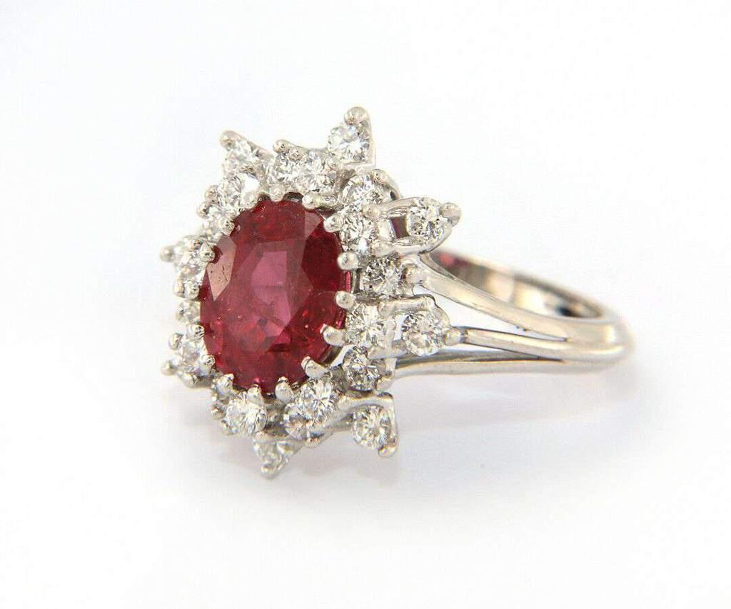 Oval Cut 2.25 CT Ruby and 1.00 CTW Diamond Halo Starburst Frame Ring in 18kt White Gold For Sale
