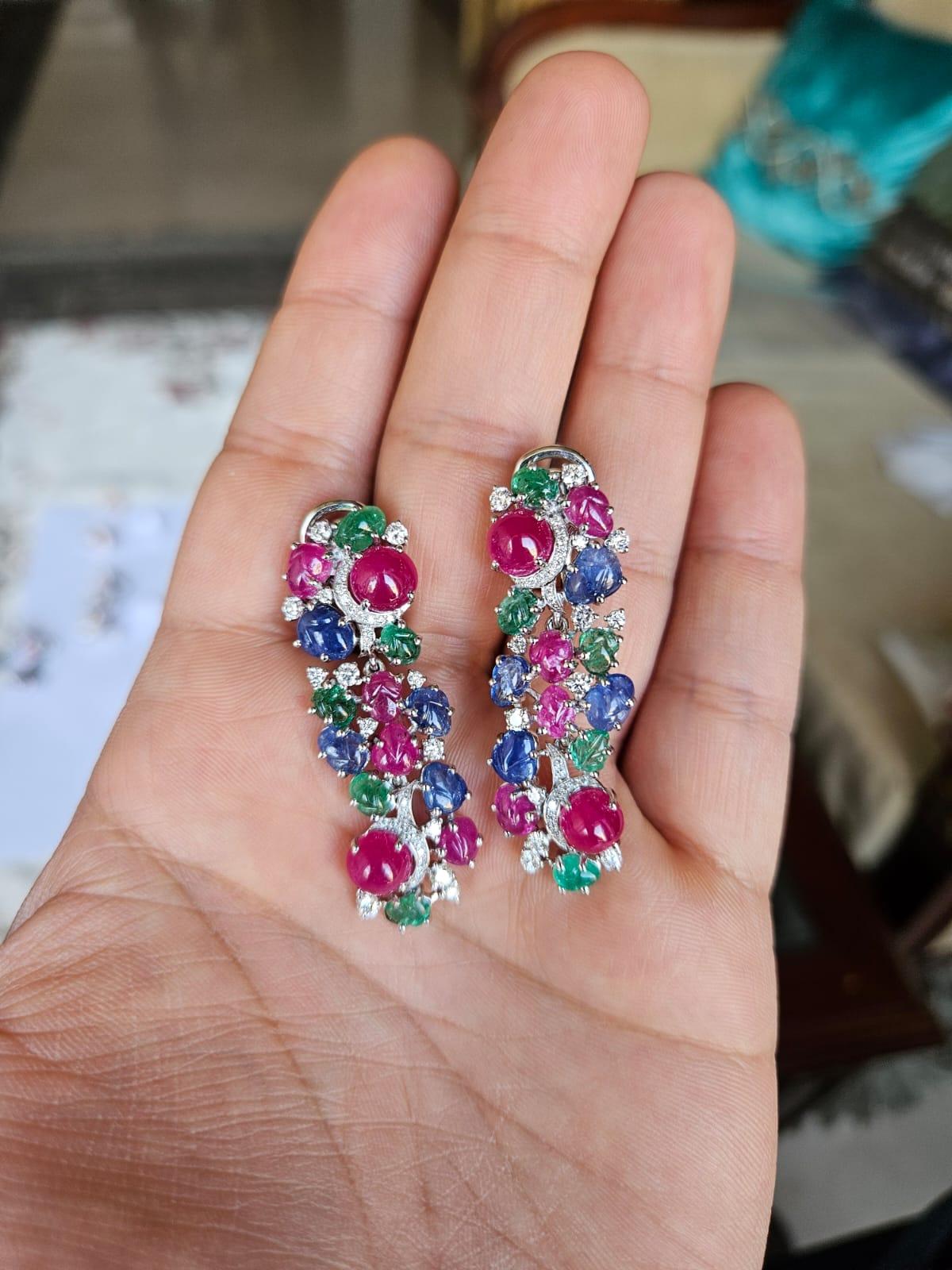 Unos preciosos pendientes araña de zafiros azules, esmeraldas y rubíes engastados en oro blanco de 18 quilates y diamantes naturales. El peso combinado de los cabujones de rubí, zafiros azules tallados, esmeraldas y rubíes es de 22,50 quilates. Los