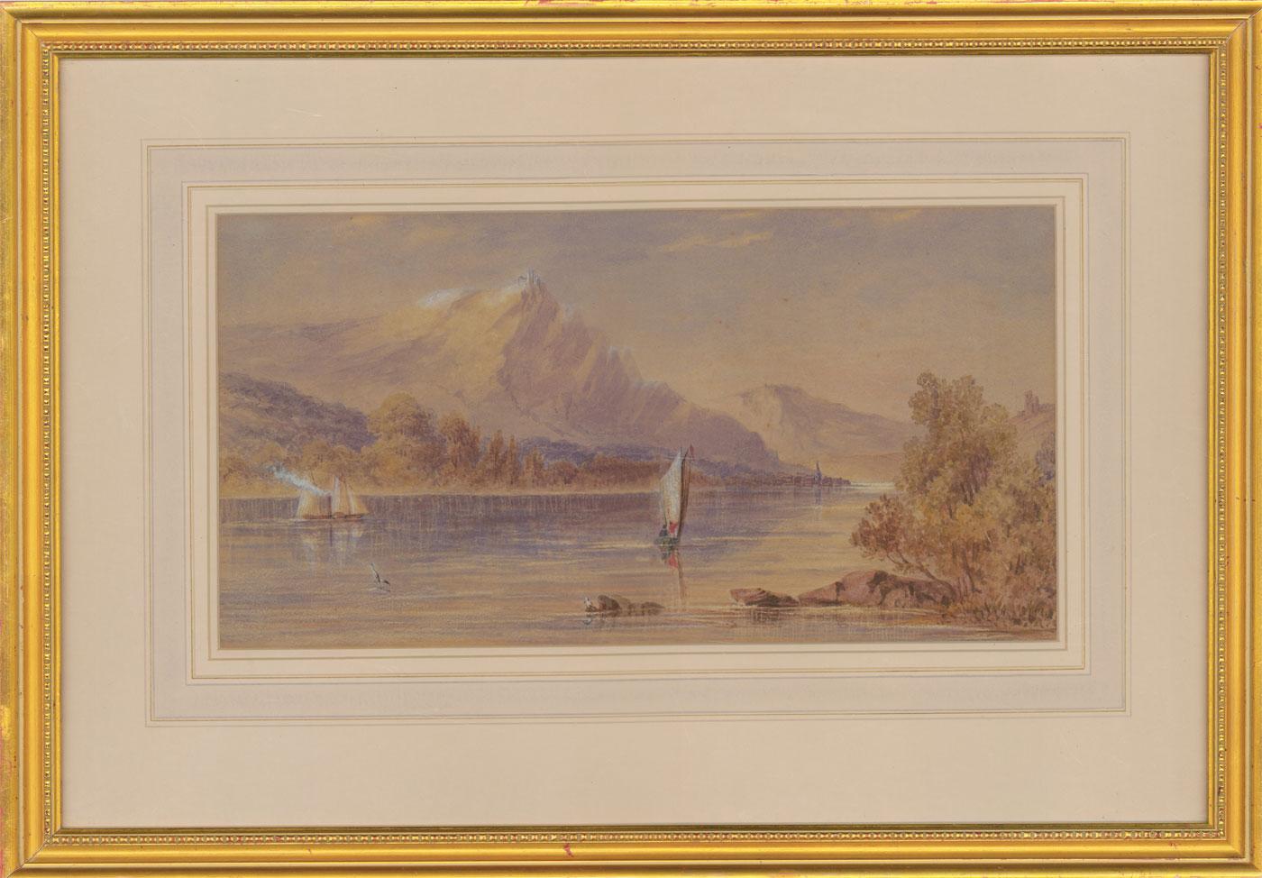 A charming early 20th Century watercolour with gouache highlights by the artist John Charles Moody (1884-1962), depicting a tranquil mountain landscape with a lake, castle ruins in the distance and boats sailing on the calm waters. Well presented in