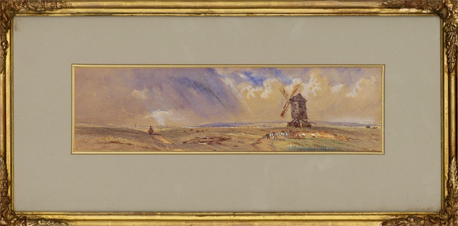 A commanding watercolour study of an open trestle post mill in the stark English countryside. The artwork is nearly presented in a gilded wood frame with molded detailing on the corners and a gilded and white double mount. On the reverse of the