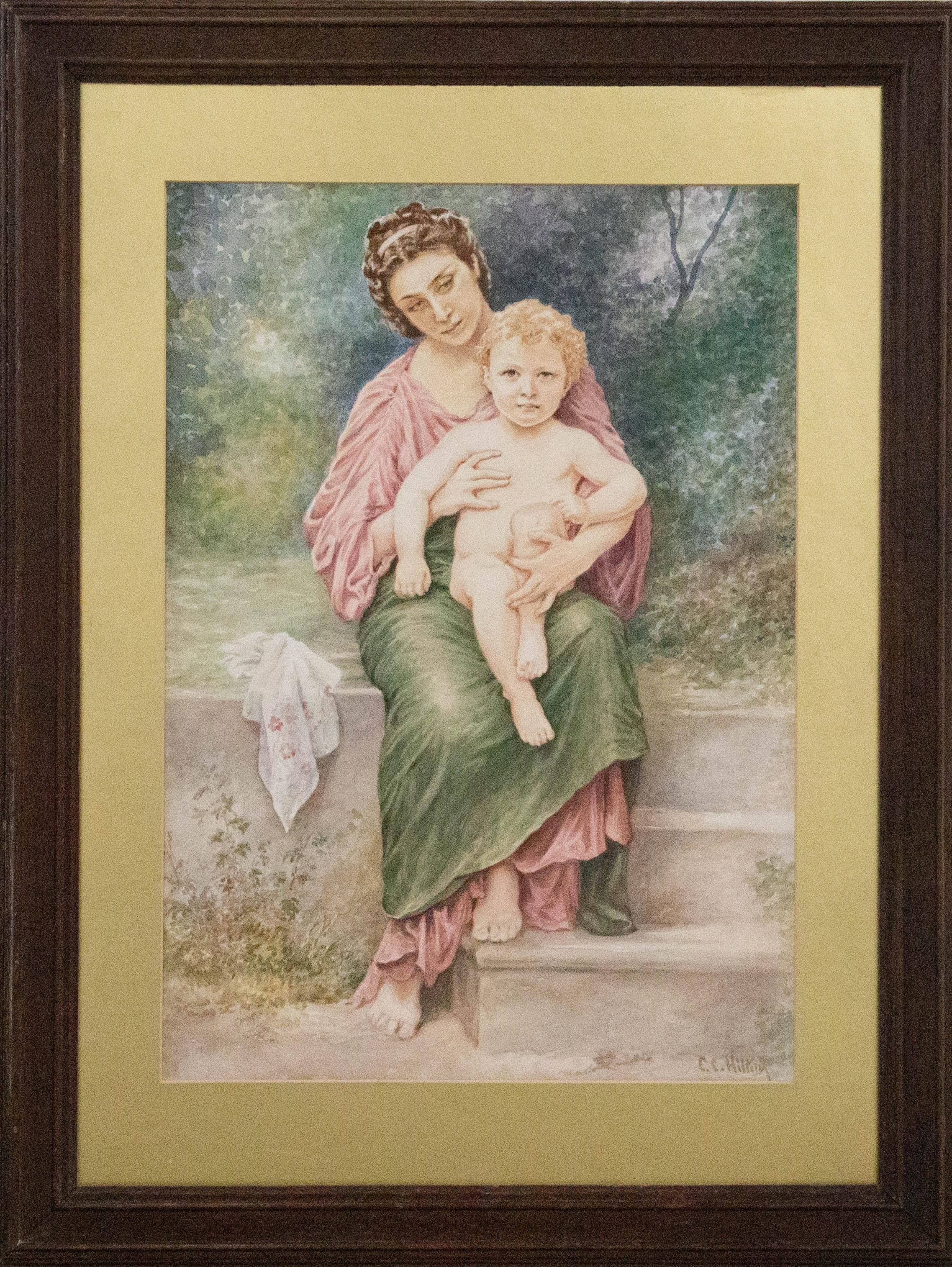 A beautiful early 20th Century (c. 1930-40) watercolour of impressive size. The scene shows a beautiful mother with dark hair in a Pre-Raphaelite style dress in pink and green, holding her young child on her lap. The mother has a far off, dreamy