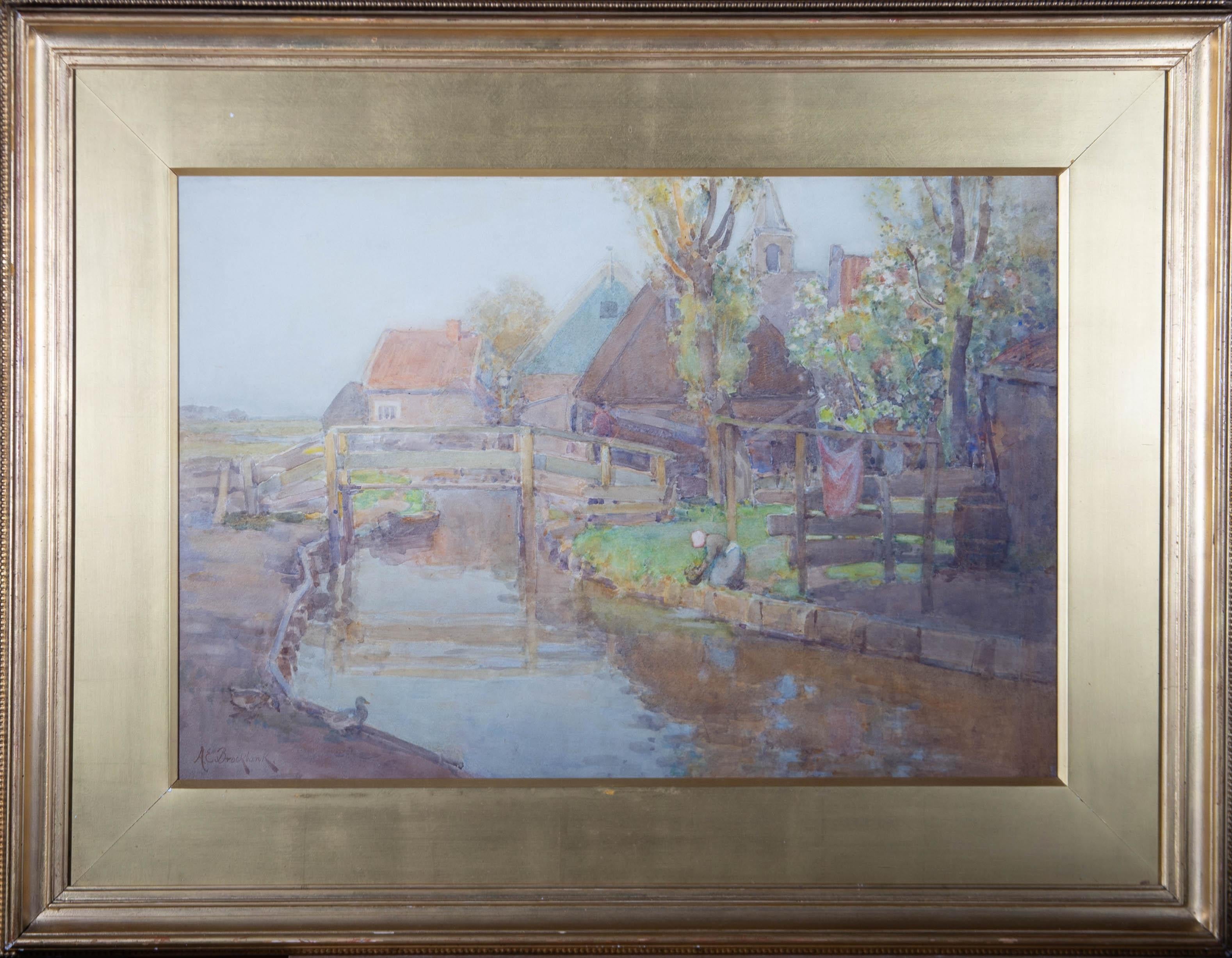 A view along a canal in the countryside, featuring a woman washing clothes before hanging them on the line beside her. Two ducks stand to the left side of the foreground. Presented glazed in a distressed gilt-effect wooden frame with a gilt-effect